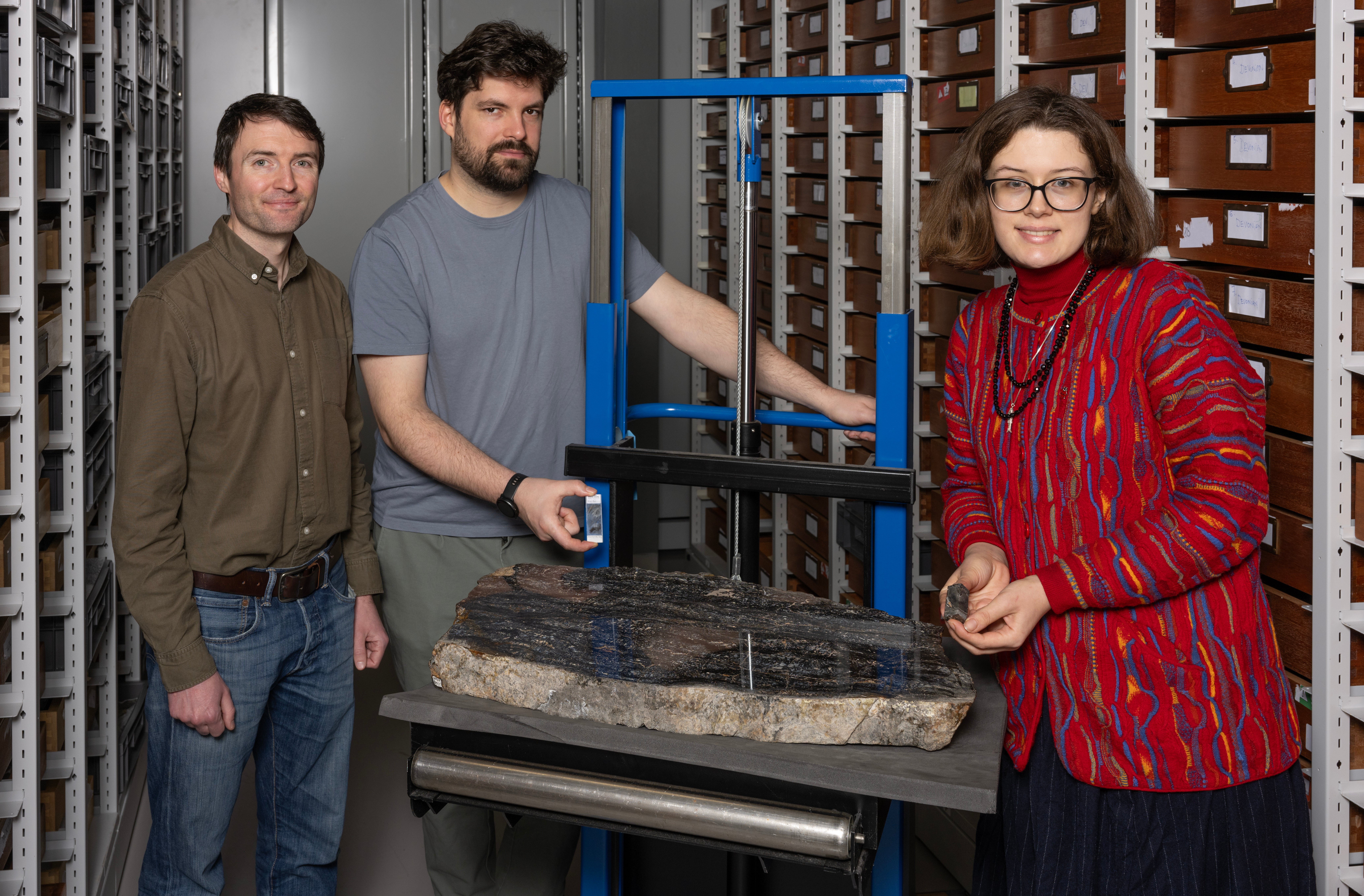 Researchers (R to L) Sandy Hetherington, Corentin Loron and Laura Cooper at the National Museums Collection Centre with sample fossils of the species Prototaxites. (Neil Hanna/PA)