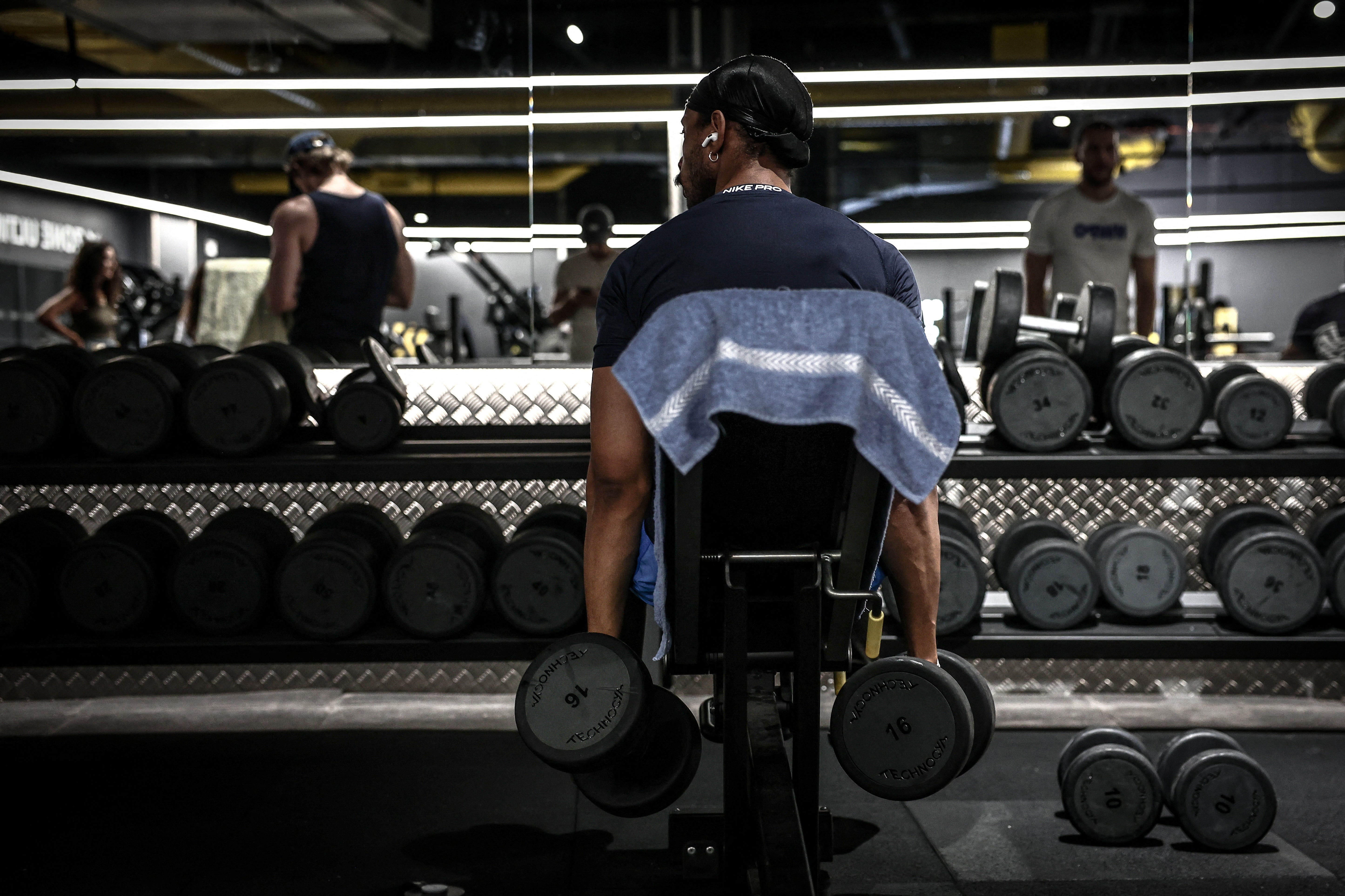 <p>File. A man lifts weights during a workout at a gym</p>