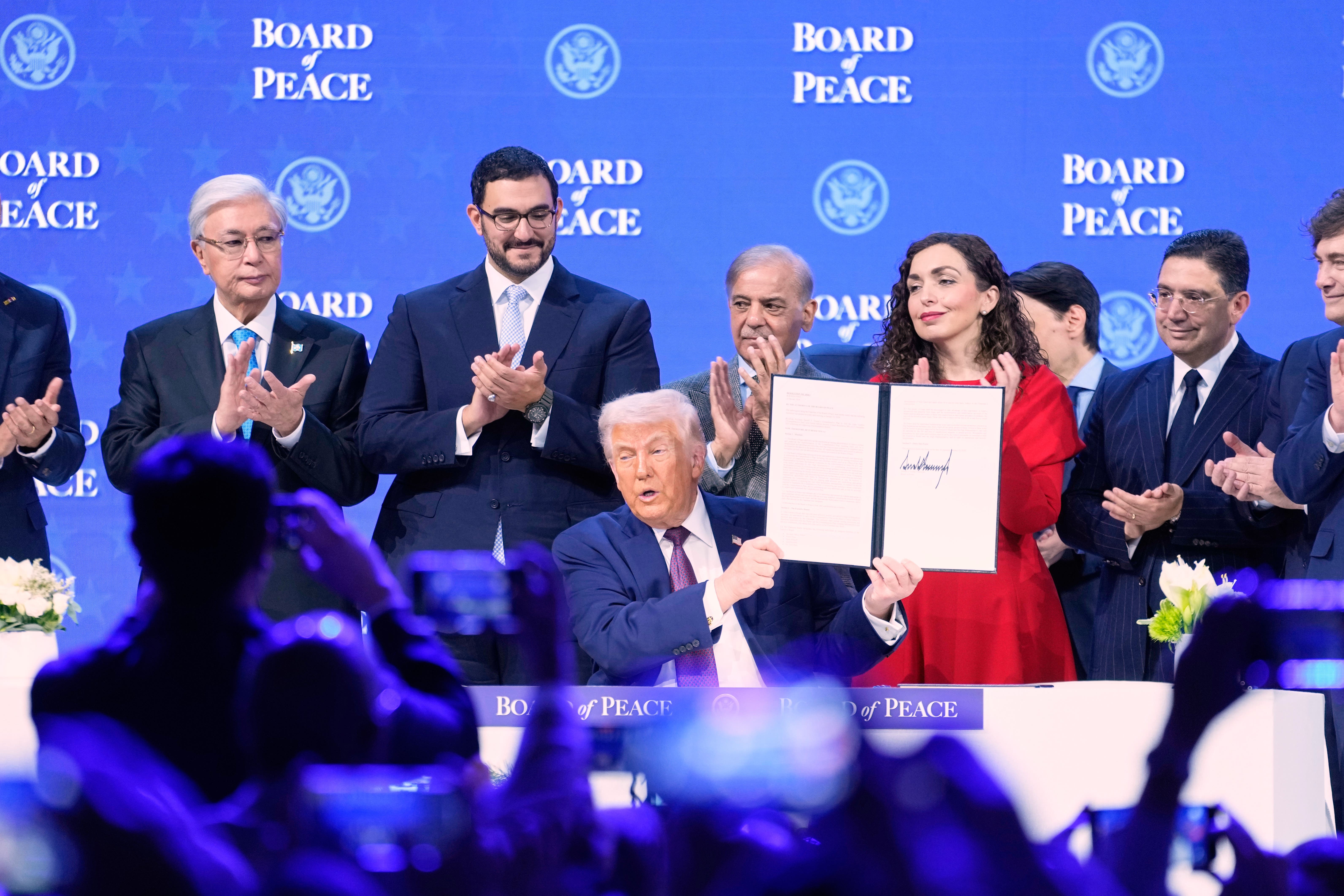 <p>Donald Trump holding the charter during a signing ceremony on his Board of Peace initiative at the World Economic Forum (AP/Markus Schreiber)</p>