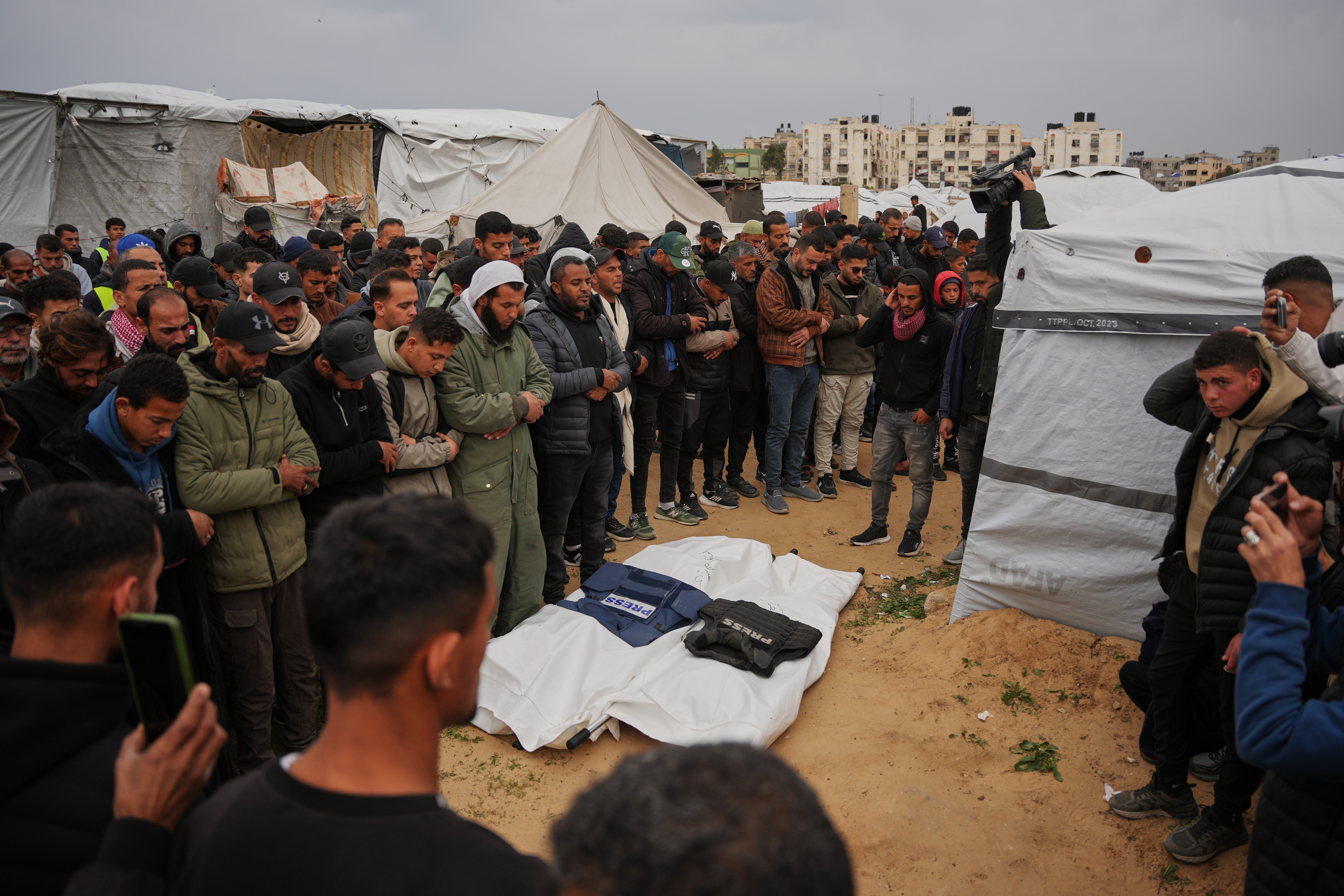 Mourners pray over the bodies of the Palestinian journalists Abd Shaat and Anas Ghoneim who were killed in an Israeli strike on an Egyptian committee's vehicle, during their funeral in Khan Younis, southern Gaza Strip, Thursday, Jan. 22, 2026