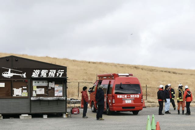 <p>Firefighters gather at a search base for a missing sightseeing helicopter near Mount Aso in Kumamoto Prefecture, southwestern Japan, Tuesday, 20 January 2026</p>