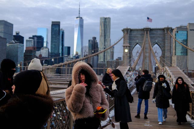 <p>People brave cold temperatures while walking on the Brooklyn Bridge ahead of a winter storm expected to bring heavy snow and ice to the region</p>