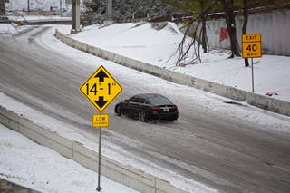Um carro dirige em uma estrada nevada em Houston, Texas, antes de uma tempestade de inverno que deverá atingir o estado neste fim de semana.