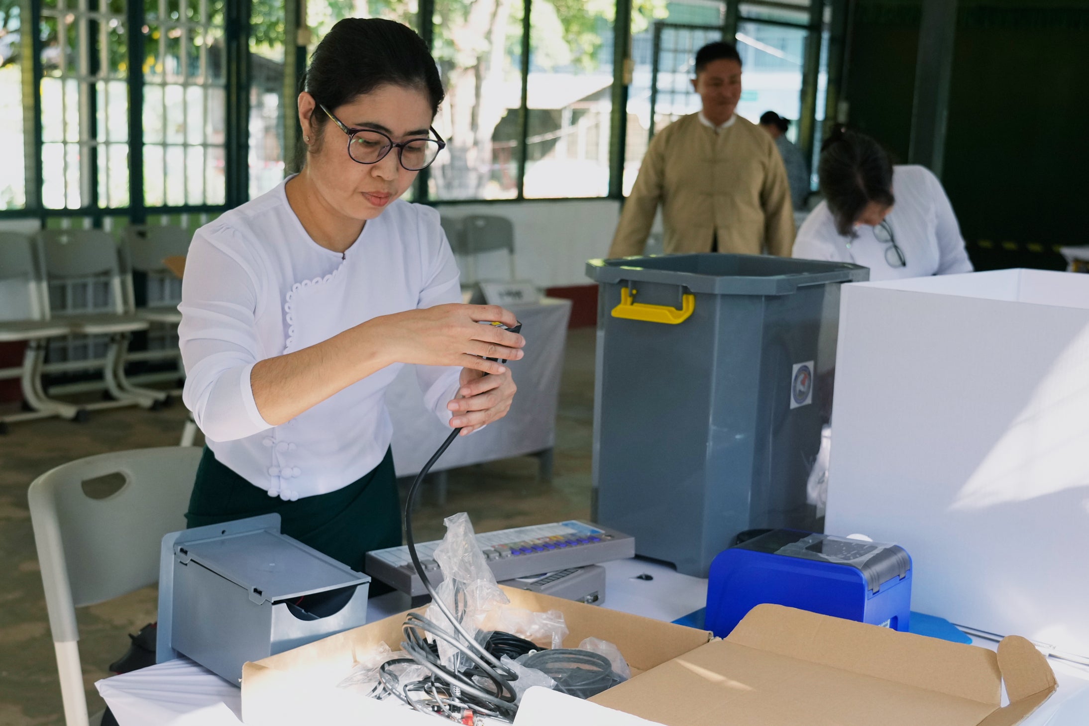 An Election Commission official sets up an electronic voting machine at a polling station in Yangon