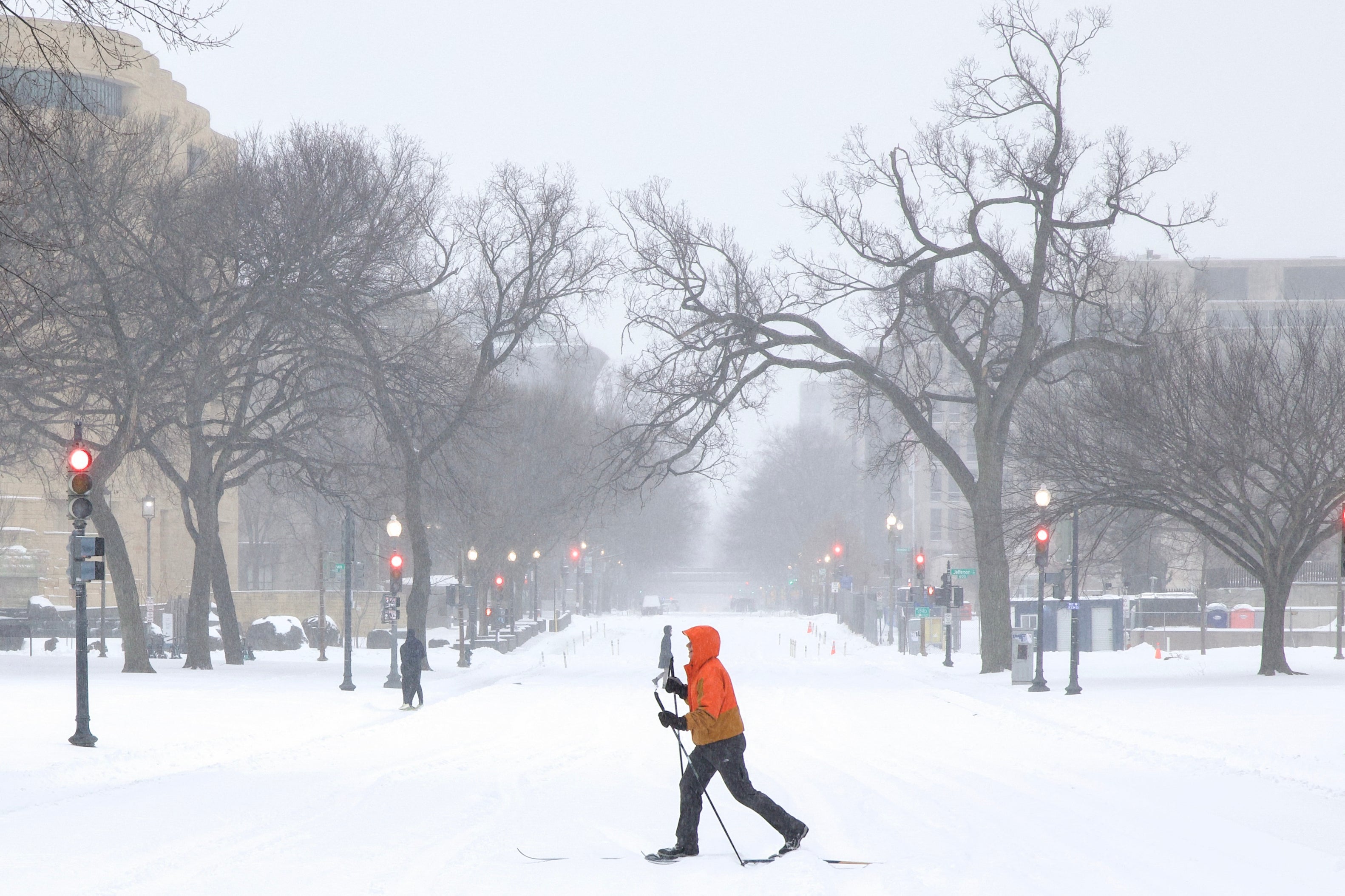 <p>A man on skis crosses a street near the National Mall as snow falls in Washington, DC, on January 25, 2026. </p>