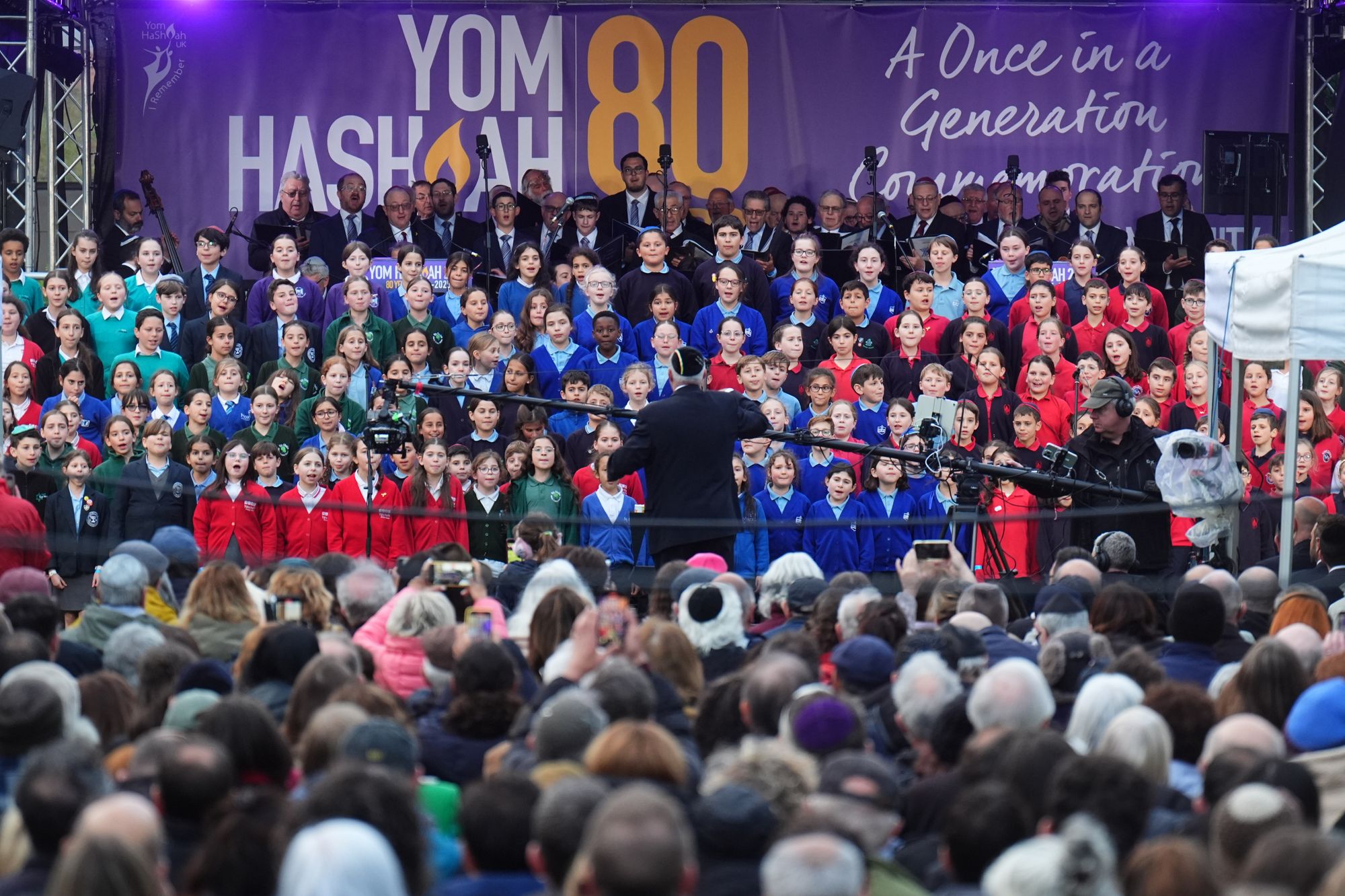 School children singing onstage at the 80th Anniversary National Yom HaShoah Commemoration, in Victoria Tower Gardens, beside the Houses of Parliament, central London on 23 April 2025