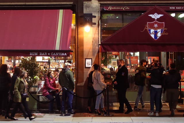 <p>People outside the Revolucion de Cuba bar in Manchester, ahead of a possible government announcement on Monday. Cities in northern England and other areas suffering a surge in Covid-19 cases may have pubs and restaurants temporarily closed to combat the spread of the virus.</p>