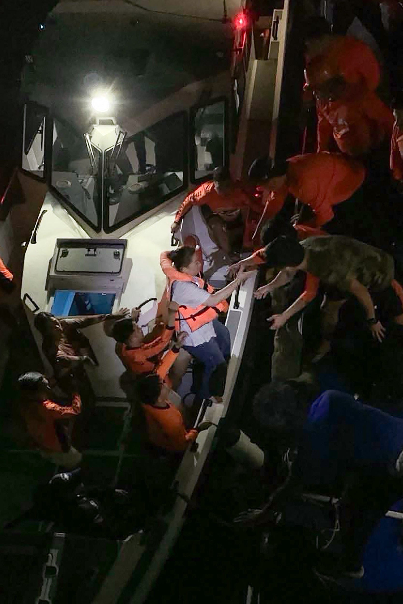 Survivors of the sunken M/V Trisha Kerstin 3 being transferred to another ship in waters off Basilan province