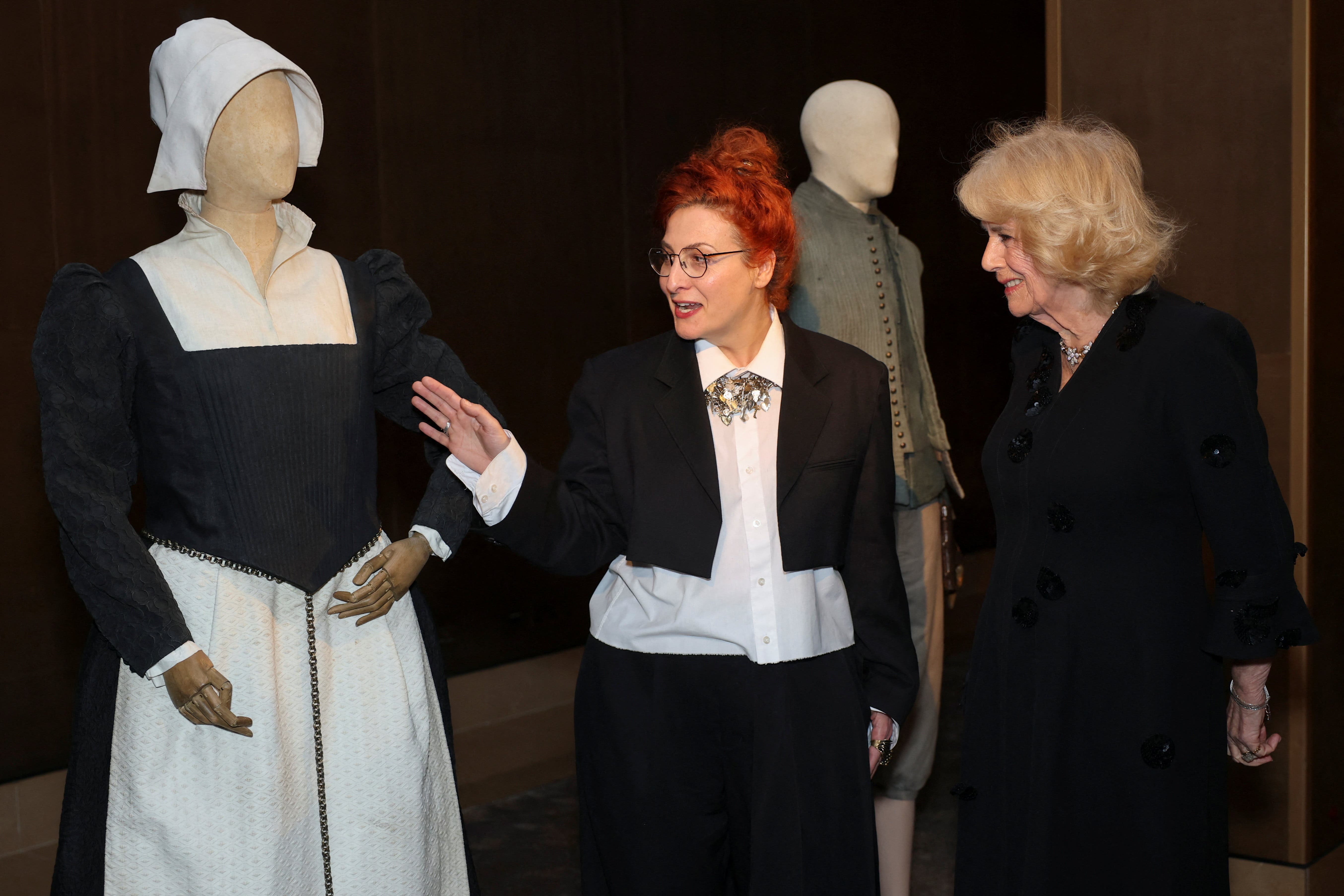 Camilla viewed a display of costumes created for the film Hamnet with costume designer Malgosia Turzanska (Isabel Infantes/PA)