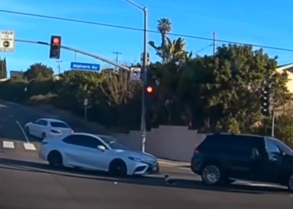 The SUV immediately stops, almost causing a traffic collision with the vehicle behind it, which also appears to swerve to avoid the child
