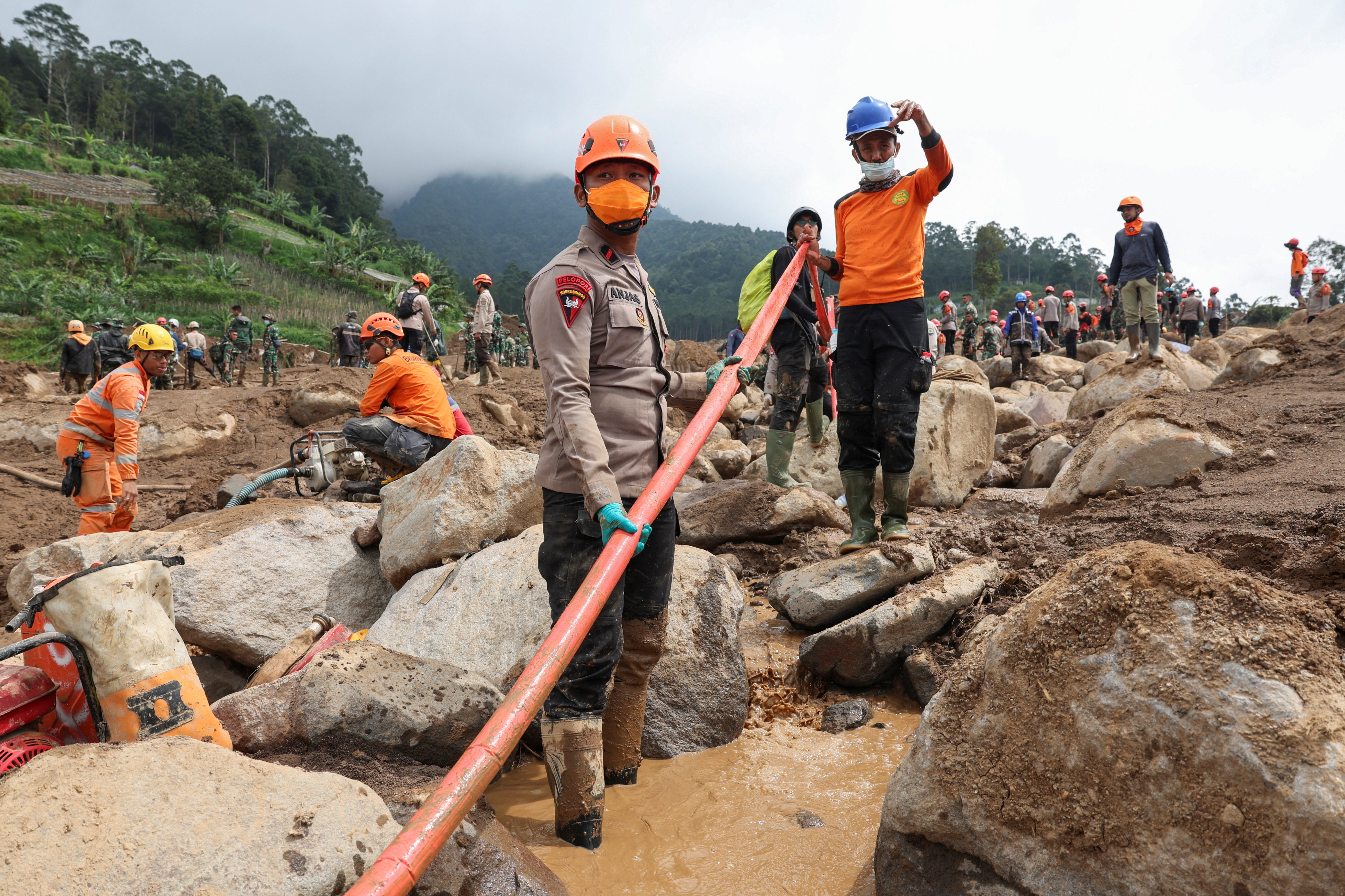 Indonesian rescue workers search for victims at the site of a landslide