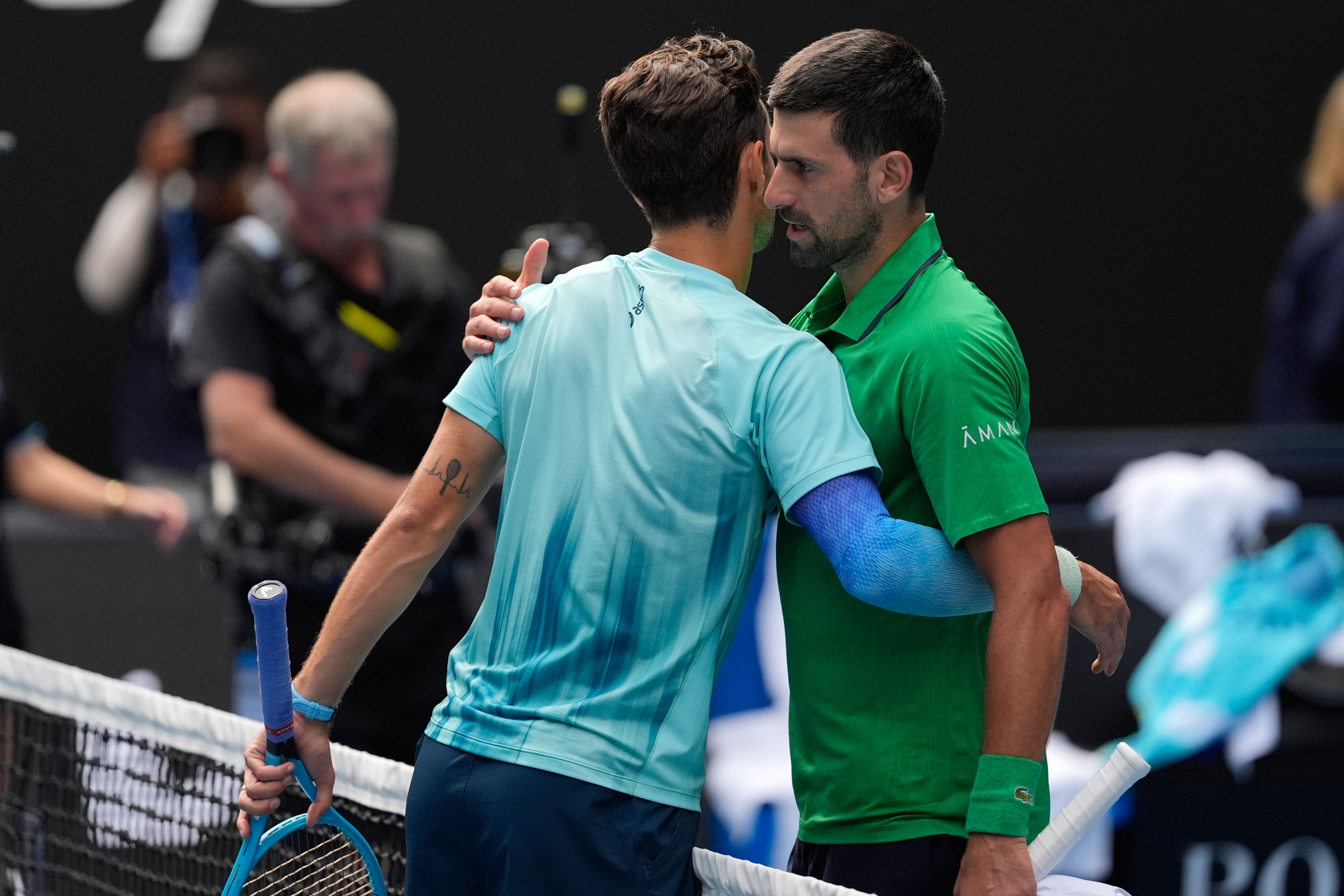 Novak Djokovic, right, embraces Lorenzo Musetti after the Italian was forced to retire from their Australian Open quarter-final (Asanka Brendon Ratnayake/AP)