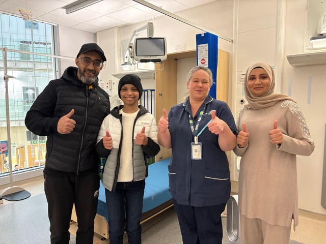 <p>Adam Rehman (second left) returned to the hospital where he underwent treatment</p>