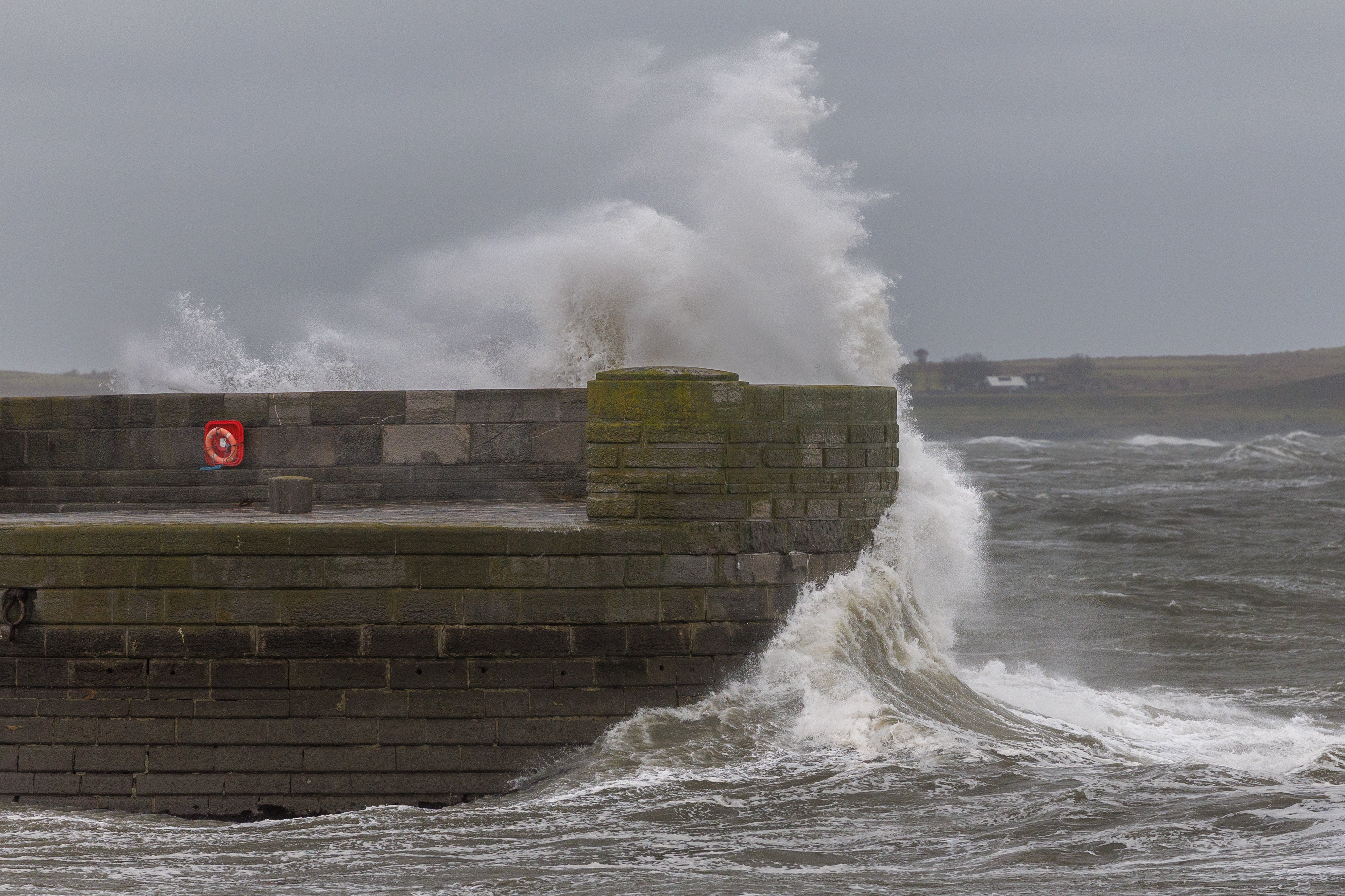 <p>Waves crash against the sea wall near the lighthouse at Donaghadee Harbour </p>