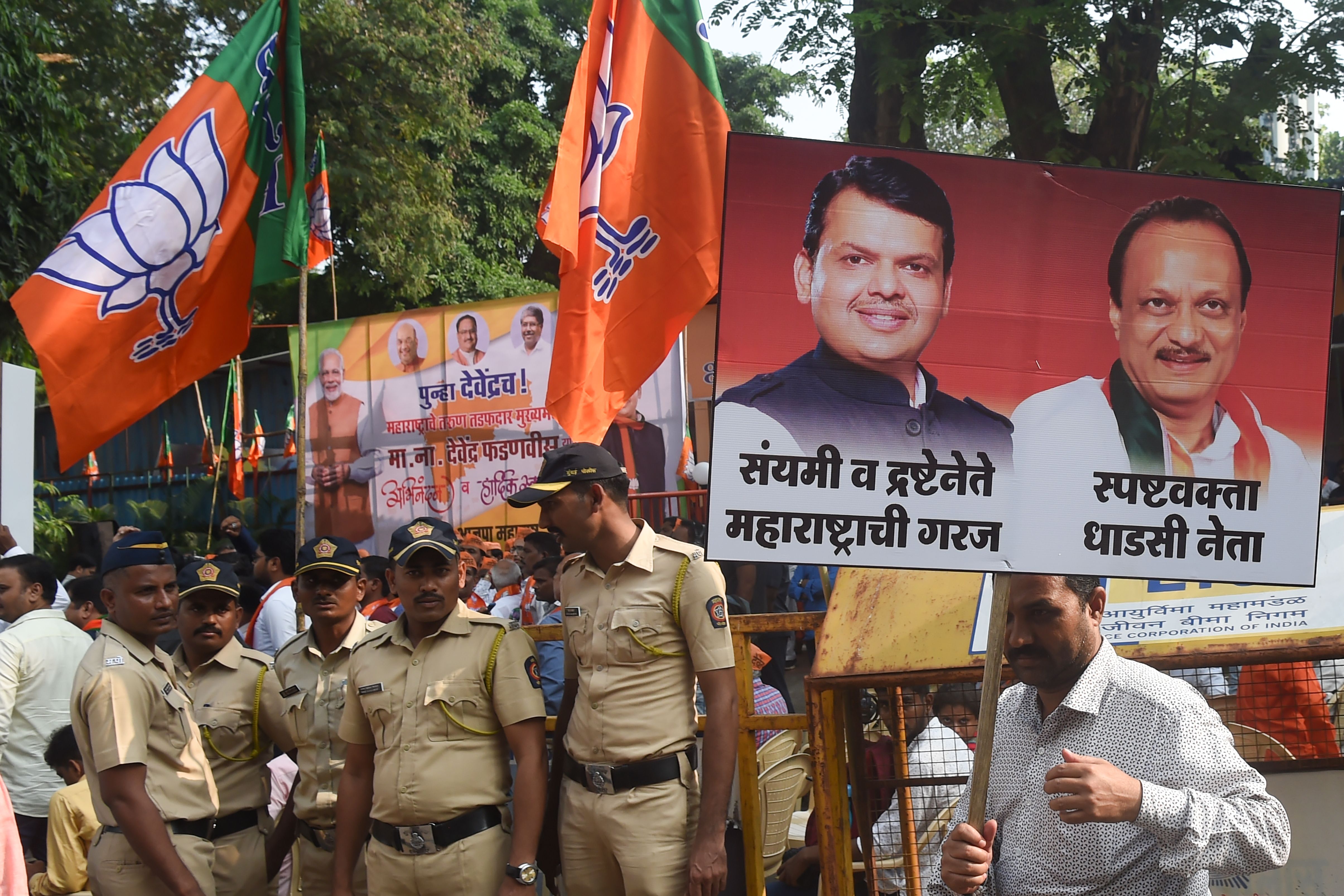 FILE: A Bharatiya Janata Party (BJP) supporter carries a poster of chief minister of the western Indian state of Maharashtra Devendra Fadnavis and Nationalist Congress Party (NCP) leader and deputy chief minister Ajit Pawar at a victory rally outside the headquarters in Mumbai on 23 November 2019
