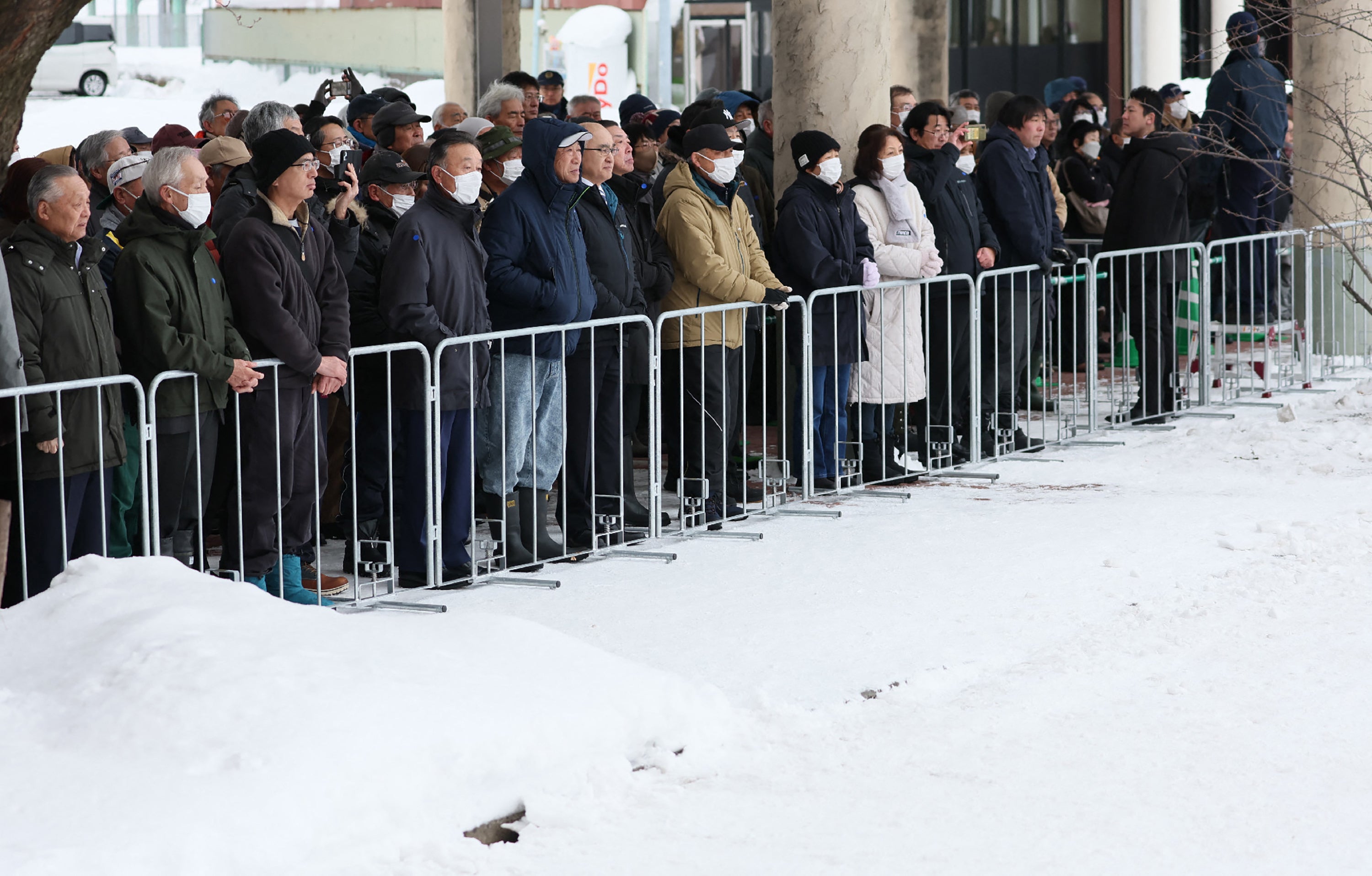 Voters listen to a party leader's speech at a House of Representatives election rally held in a snow-covered venue in Hirosaki, Aomori Prefecture