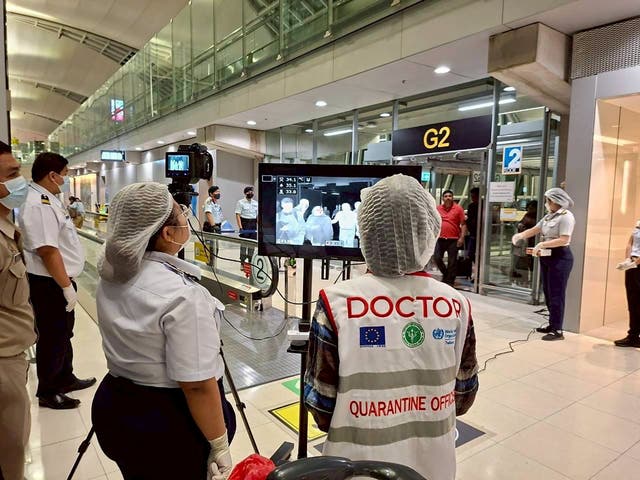 <p>Airport health authorities wearing protective masks monitor passengers from international flights arriving at Suvarnabhumi International Airport in Bangkok, Thailand.</p>