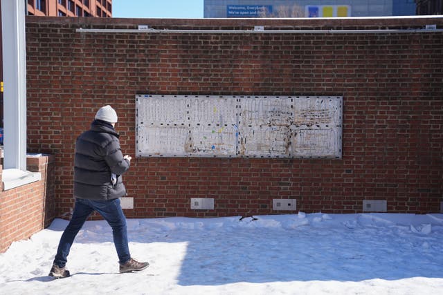 <p>A person moves to photograph the location of the now removed explanatory panels that were part of an exhibit on slavery at President's House Site in Philadelphia</p>