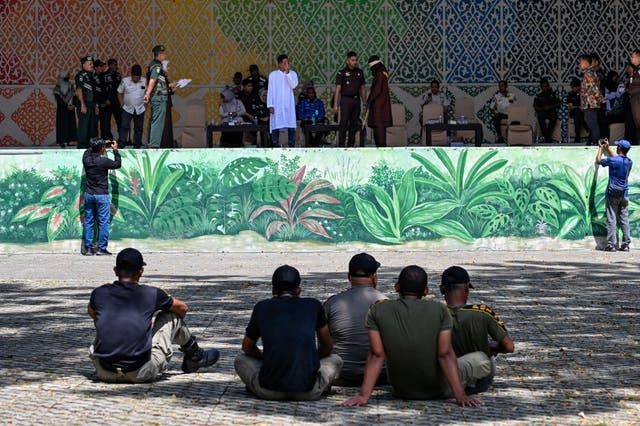 <p>A man accused of having sex outside marriage waits before being publicly caned by a member of the Sharia police in Banda Aceh on 29 January 2026</p>