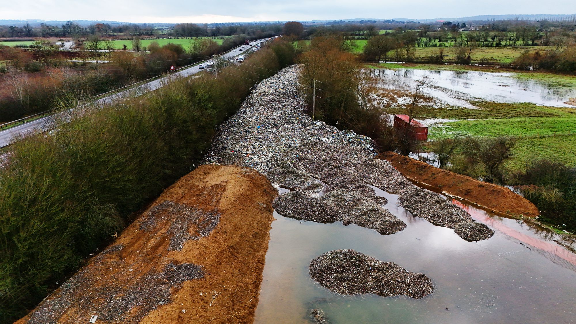 The 150m long mountain of rubbish that has been illegally dumped beside the A34 and near the River Cherwell in Kidlington
