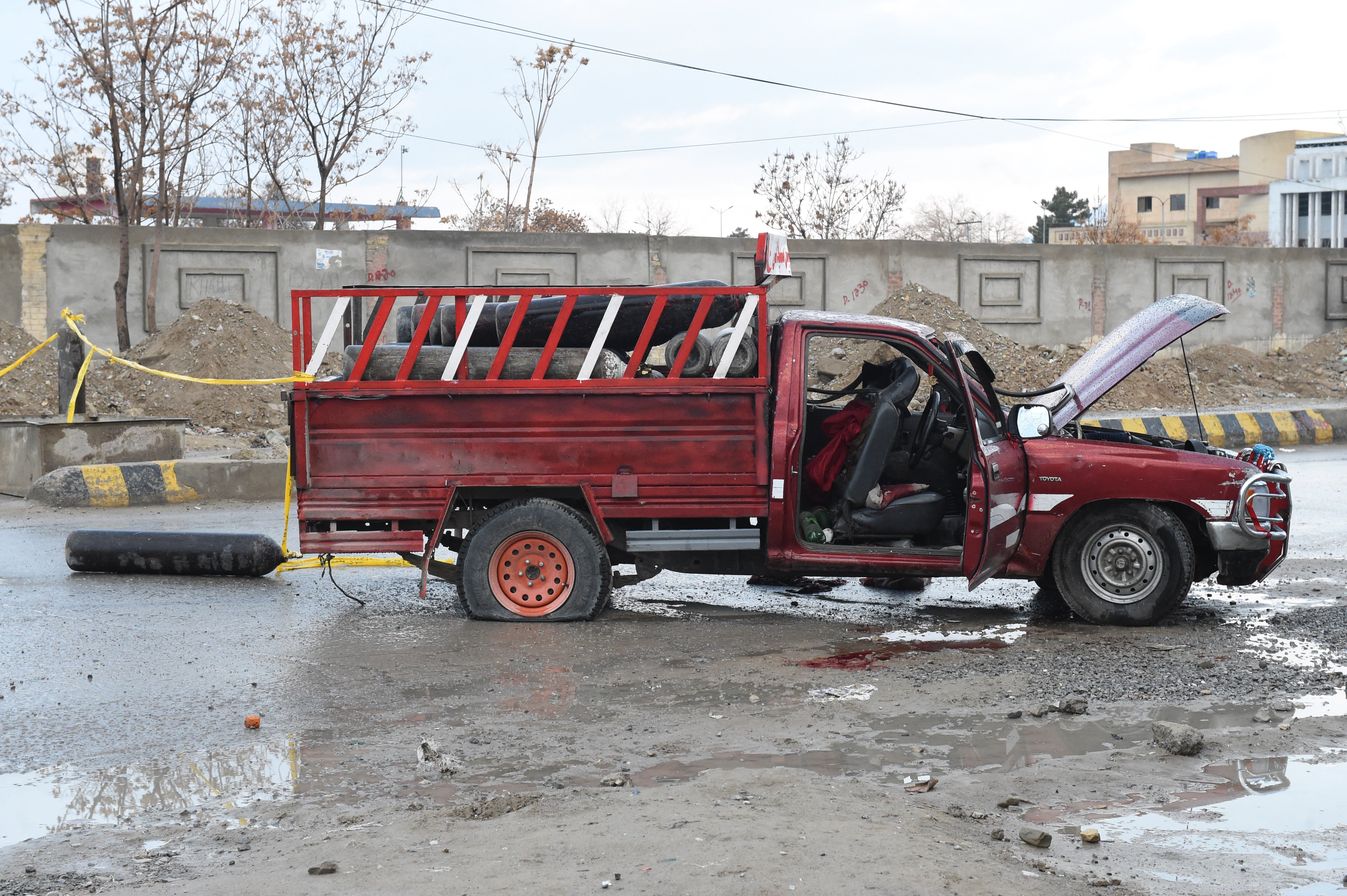 A damaged vehicle is pictured near the blast site