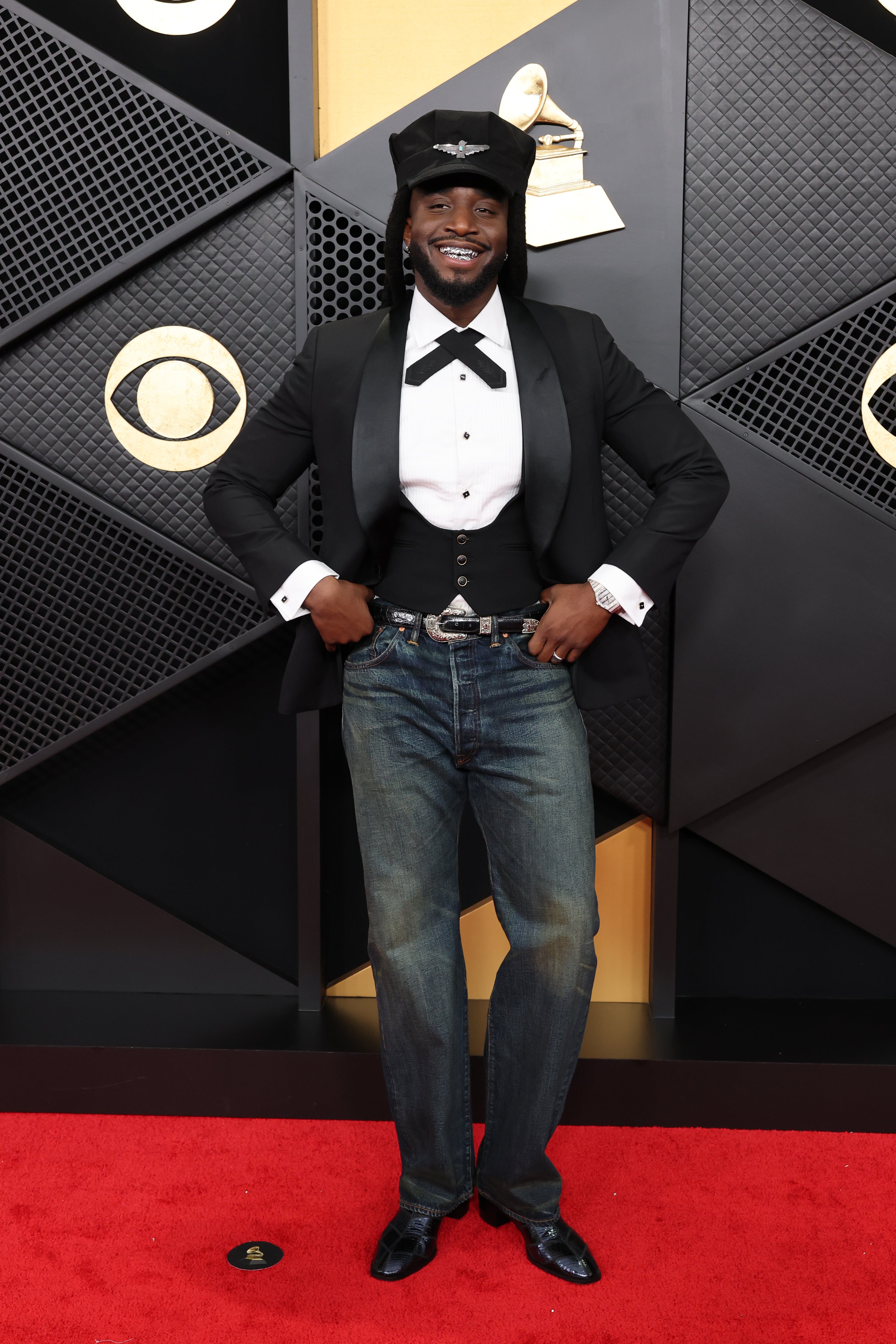 The ‘A Bar Song’ singer's mismatched outfit combined casual and black tie, with jeans and a flashy belt on the bottom, and a tuxedo jacket and pilot’s cap on top