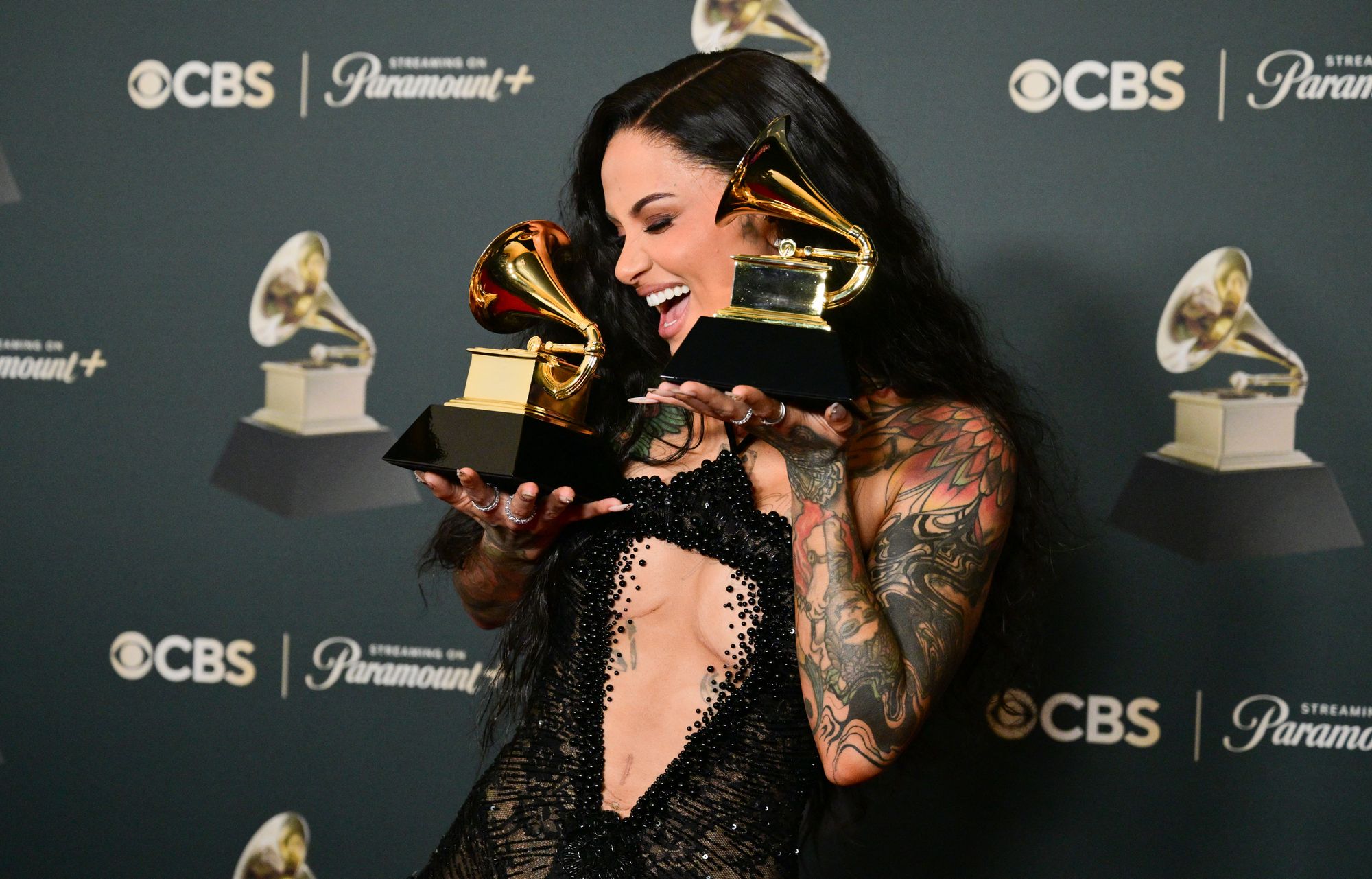 The singer also posed with the two Grammy Awards she already won this evening, one for Best R&B Performance and another for Best R&B Song. In the lace gown, she had her arm and neck tattoos on full display