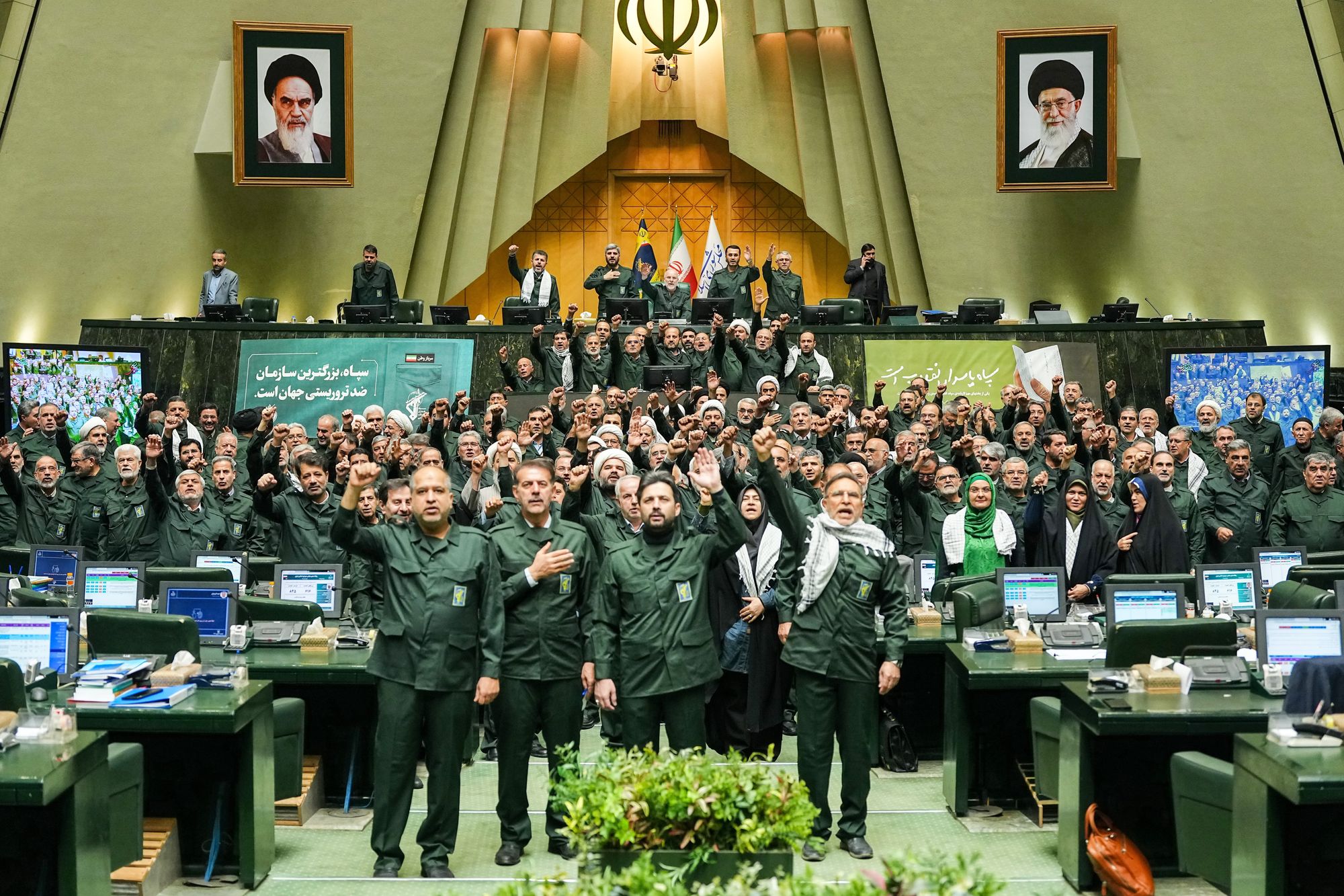 Iranian lawmakers chant slogans as they wear the Revolutionary Guard's uniform in a session of parliament on 1 February