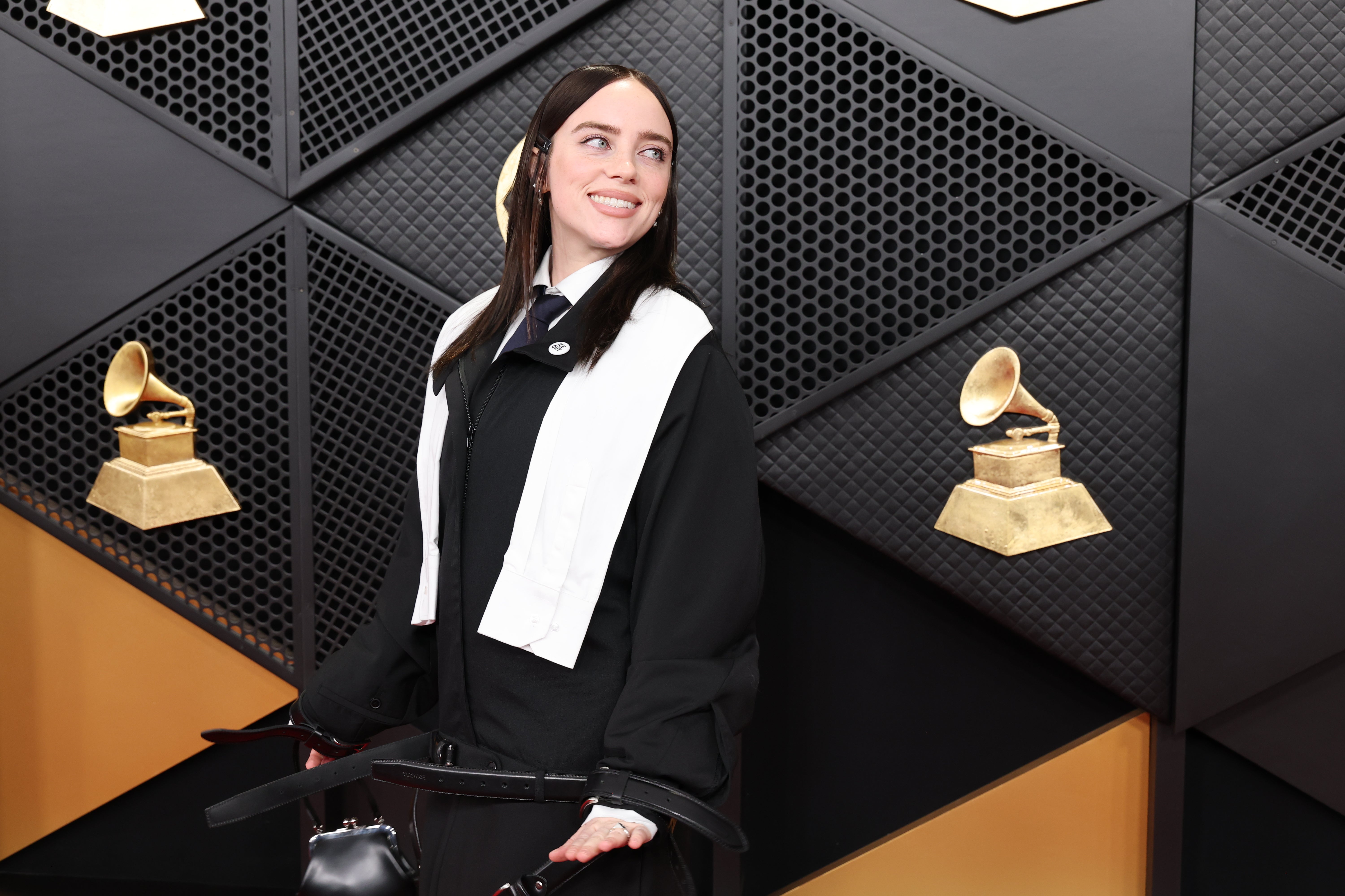Billie Eilish was a style icon in a dark blue tie, white collared shirt, and black jacket, with a white stole