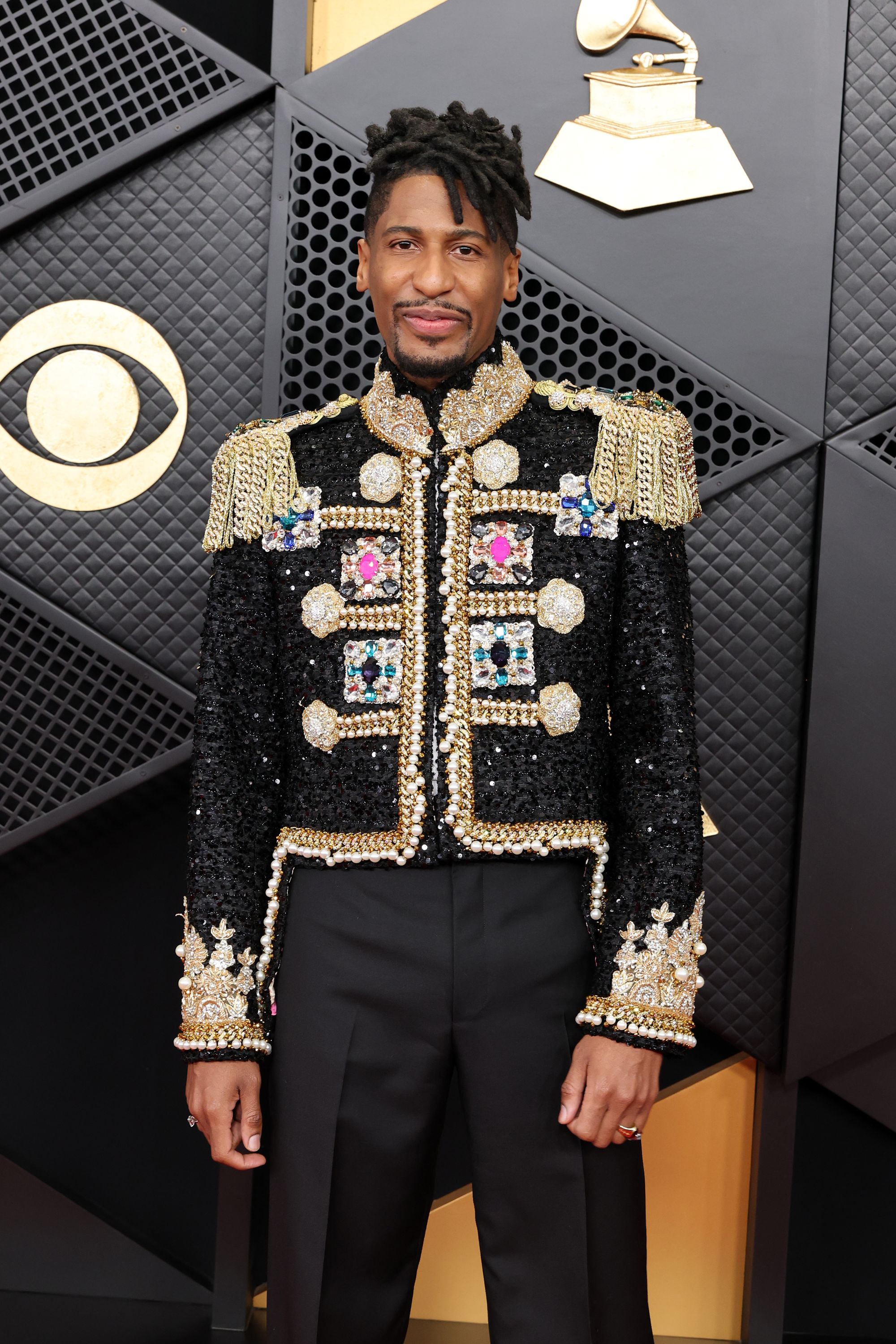Jon Batiste hopped in on the sequins trend, but with his own twist, wearing a black jacket adorned in multi-colored jewels and gold cuffs. His jacket also featured gold, fringe shoulder pads