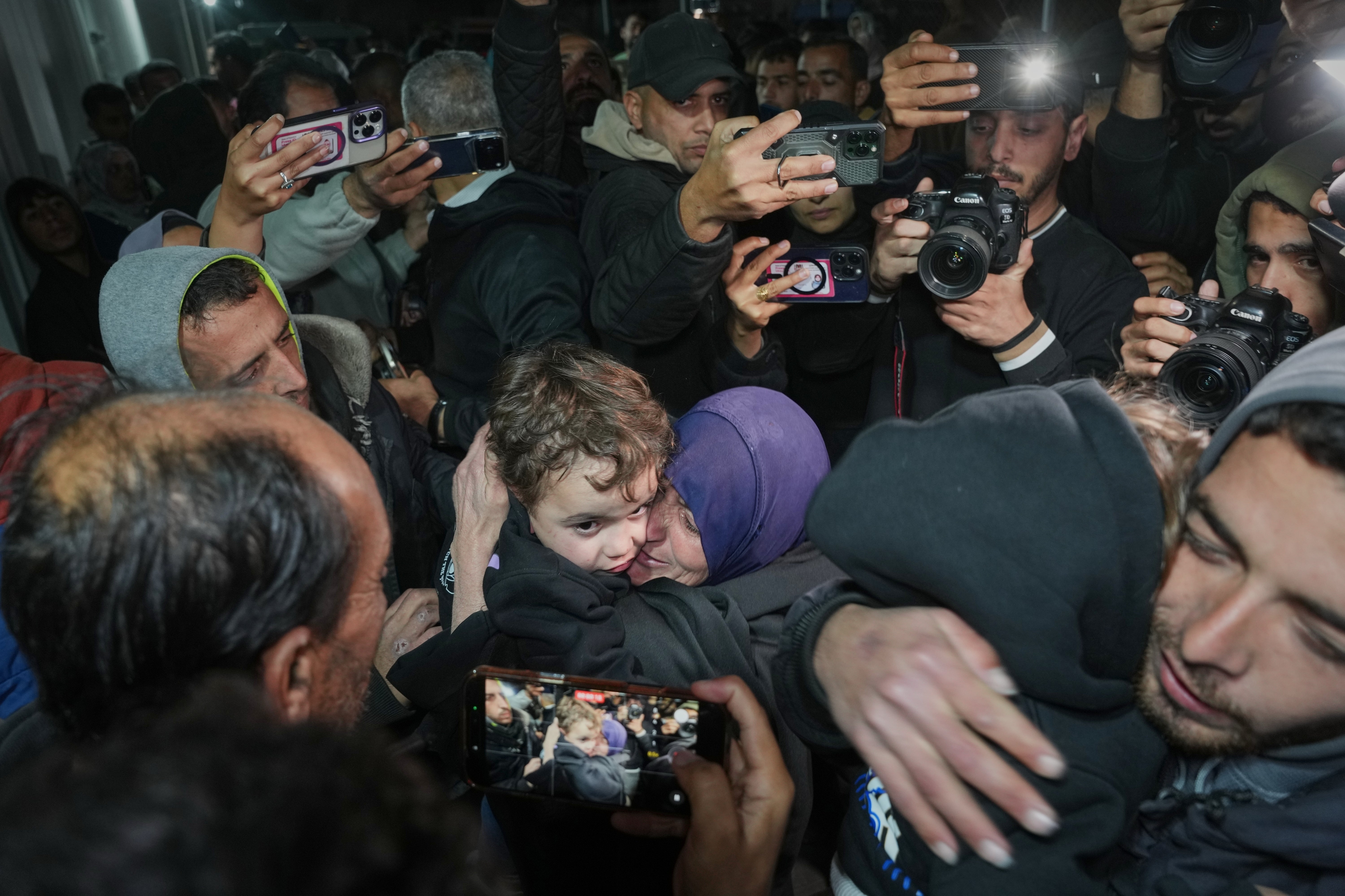 Najat Rubaie, centre right, embraces one of her grandsons after they arrive with their mother as part of a group of about a dozen Palestinian returnees allowed back into Gaza