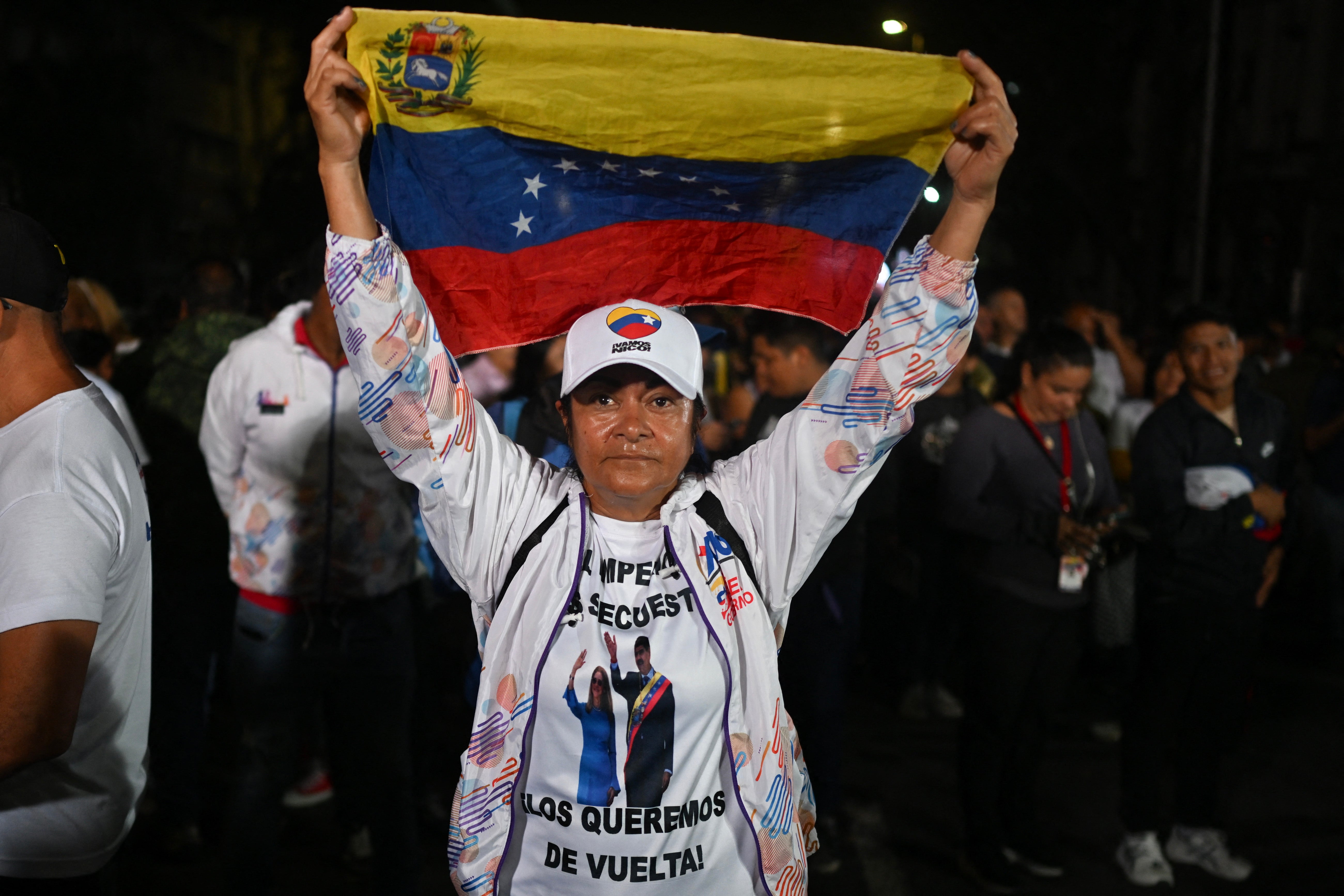 A supporter of ousted president Nicolas Maduro waves a national flag as she takes part in a vigil in Caracas