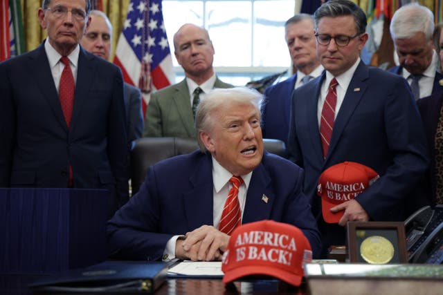 President Donald Trump surrounded by senior Republicans including House Speaker Mike Johnson