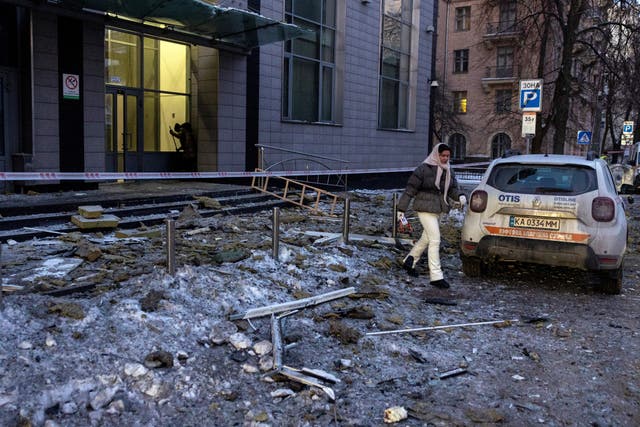 <p>A woman walks through debris outside an apartment building that was struck by a drone during Russian missile and drone attacks in Kyiv, Ukraine</p>