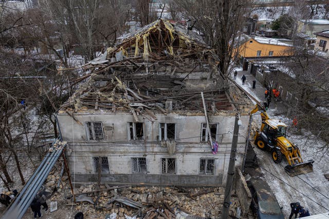 <p>This aerial photograph shows a damaged residential building as municipal workers clean debris next to it following a Russian overnight drone attack in Odesa on 4 February</p>