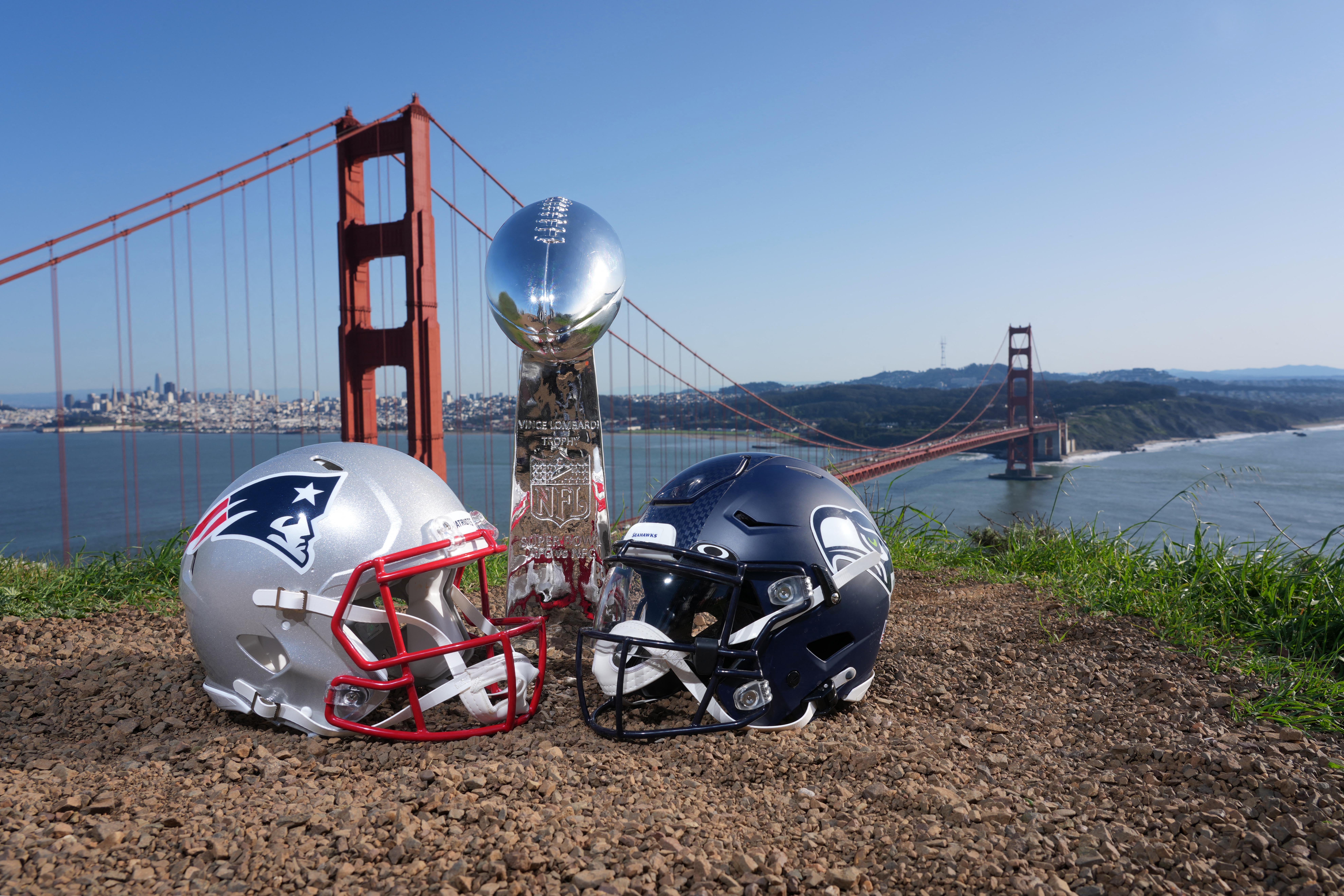 <p>New England Patriots and Seattle Seahawks helmets with a Vince Lombardi Super Bowl trophy at the Golden Gate bridge.</p>