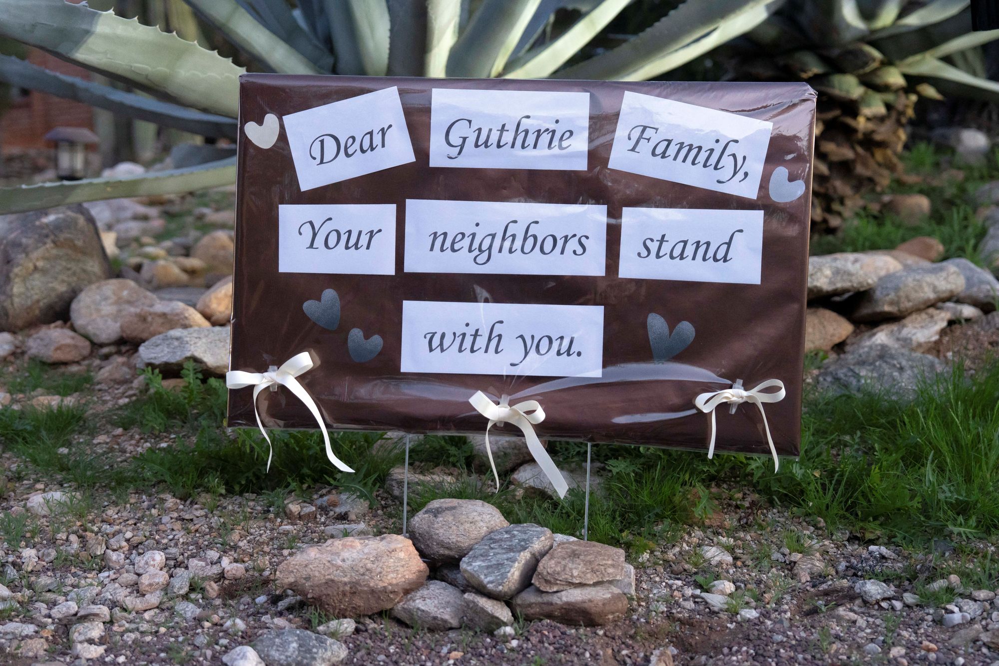 A sign outside Nancy Guthrie's home that reads, 'Dear Guthrie family, your neighbors stand with you'