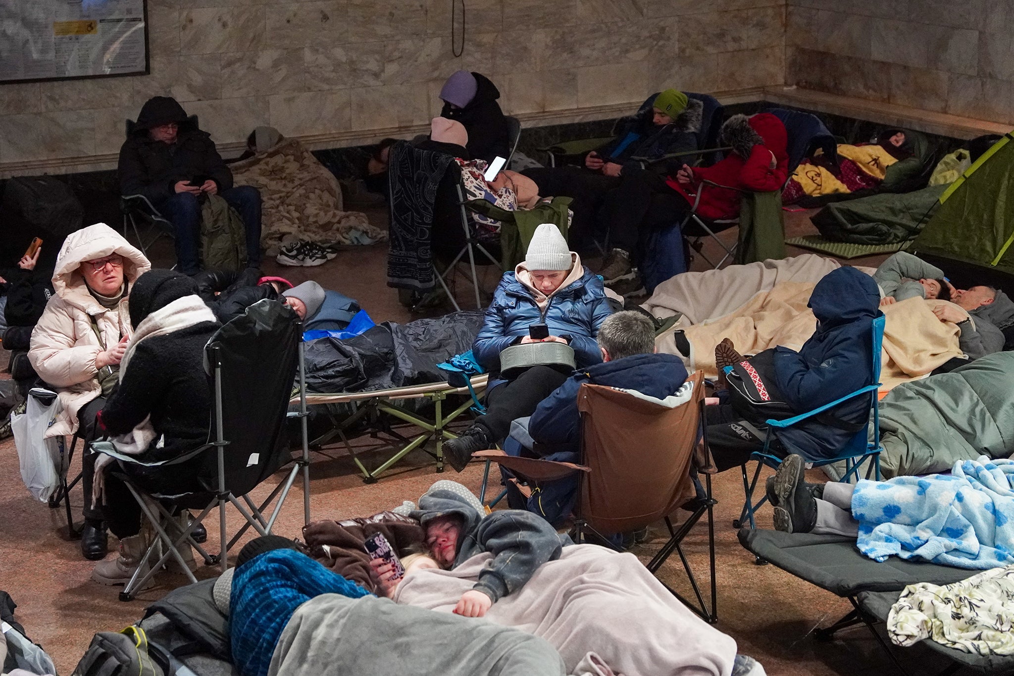 People take shelter at a metro station during a Russian air attack in Kyiv