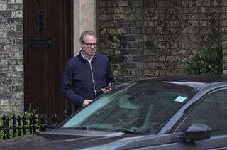 An unidentified man outside Lord Peter Mandelson's house in north-west London