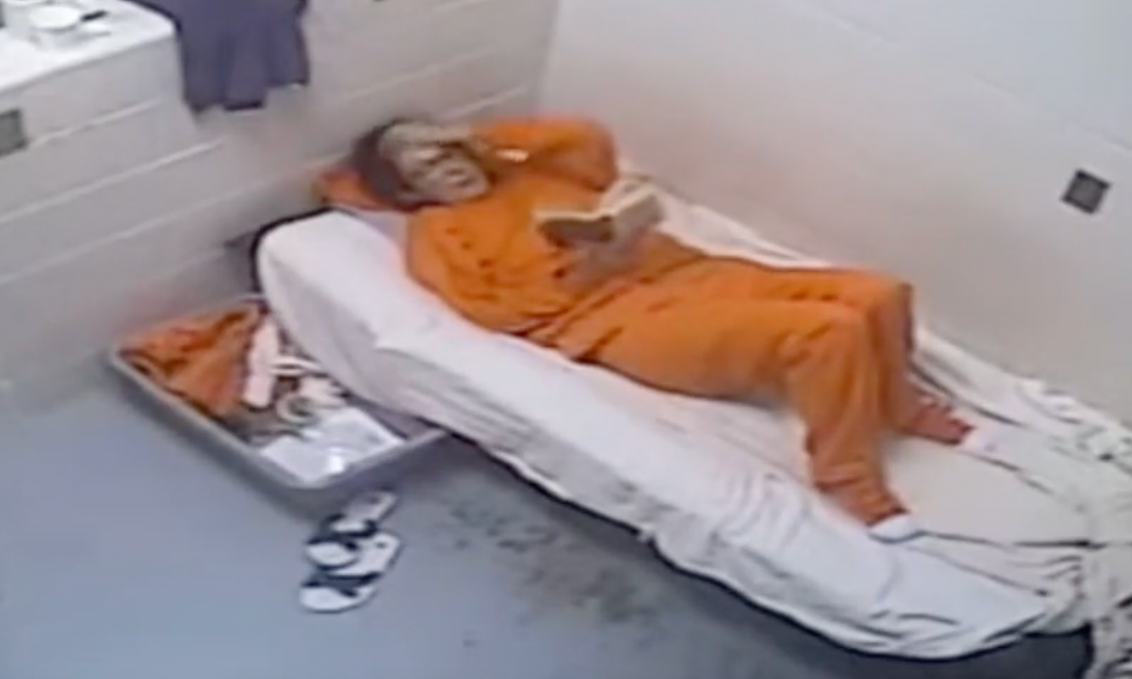 In the eerie footage, Maxwell can be seen reclining on her bed while reading
