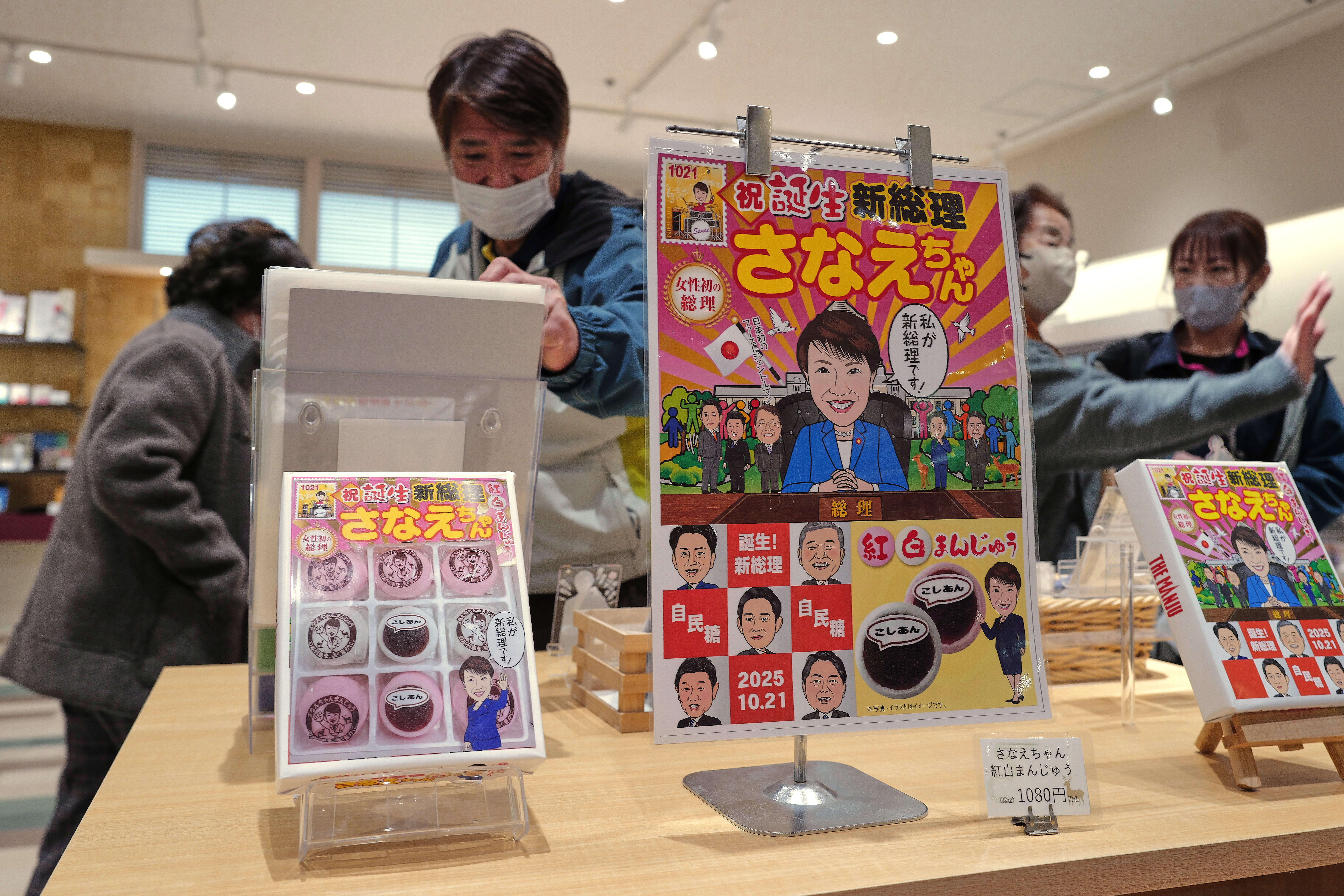 FILE- Visitors look at souvenir items featuring Japanese Prime Minister Sanae Takaichi at a shop in Nara, Takaichi's hometown, western Japan, Jan. 13, 2026. (AP Photo/Eugene Hoshiko, File)