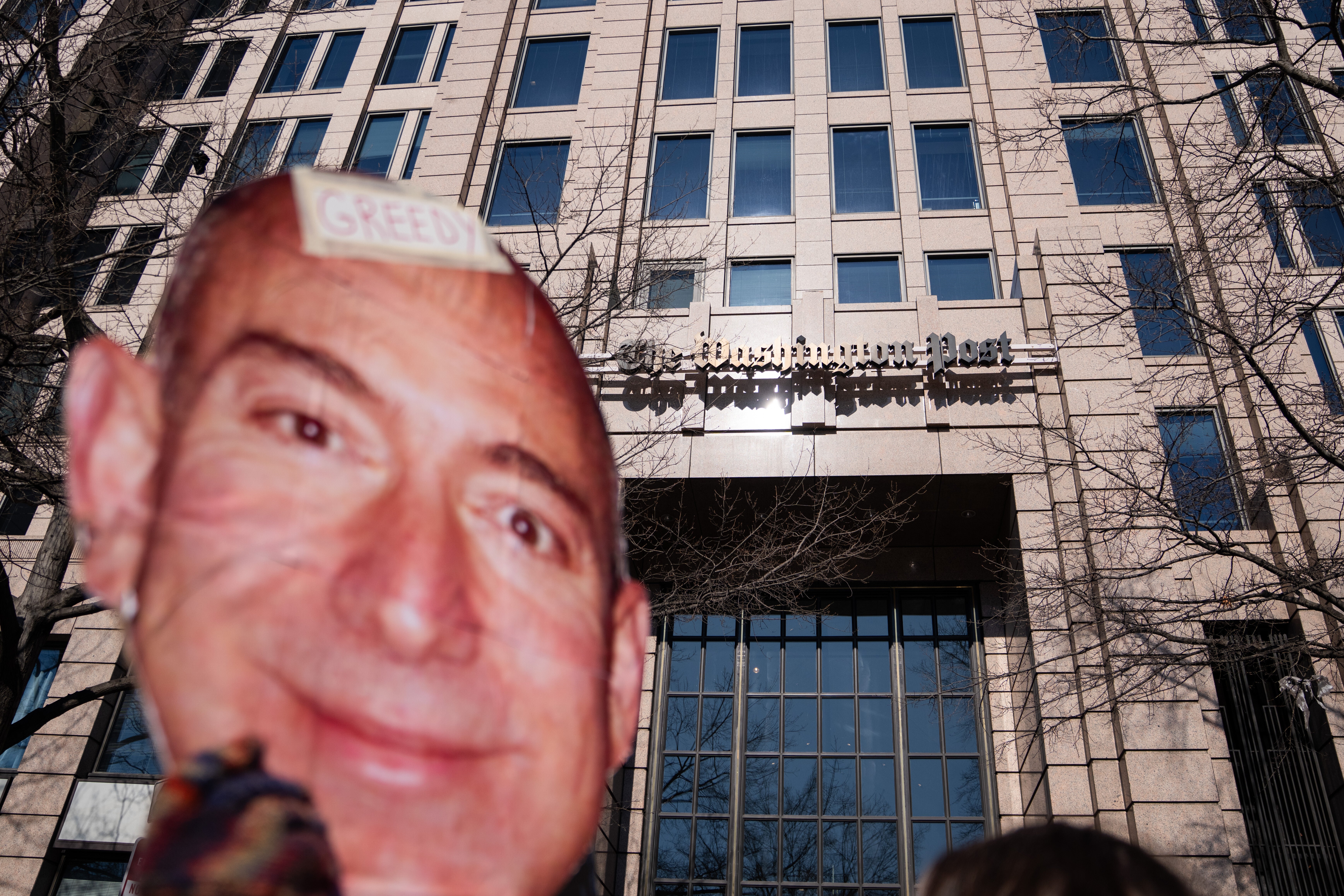 A protester holds a cutout of Jeff Bezos' face outside of the Washington Post office following a mass layoff, Thursday, Feb. 5, 2026, in Washington.