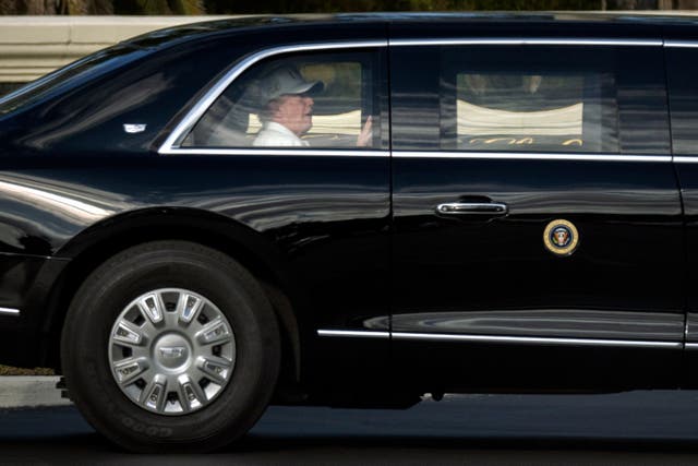 <p>President Donald Trump rides in his limousine as he leaves the Trump International Golf Club</p>
