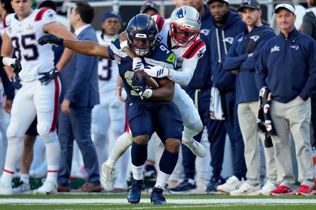 <p>Seattle Seahawks running back Kenneth Walker III is tackled by New England Patriots cornerback Marcus Jones</p>