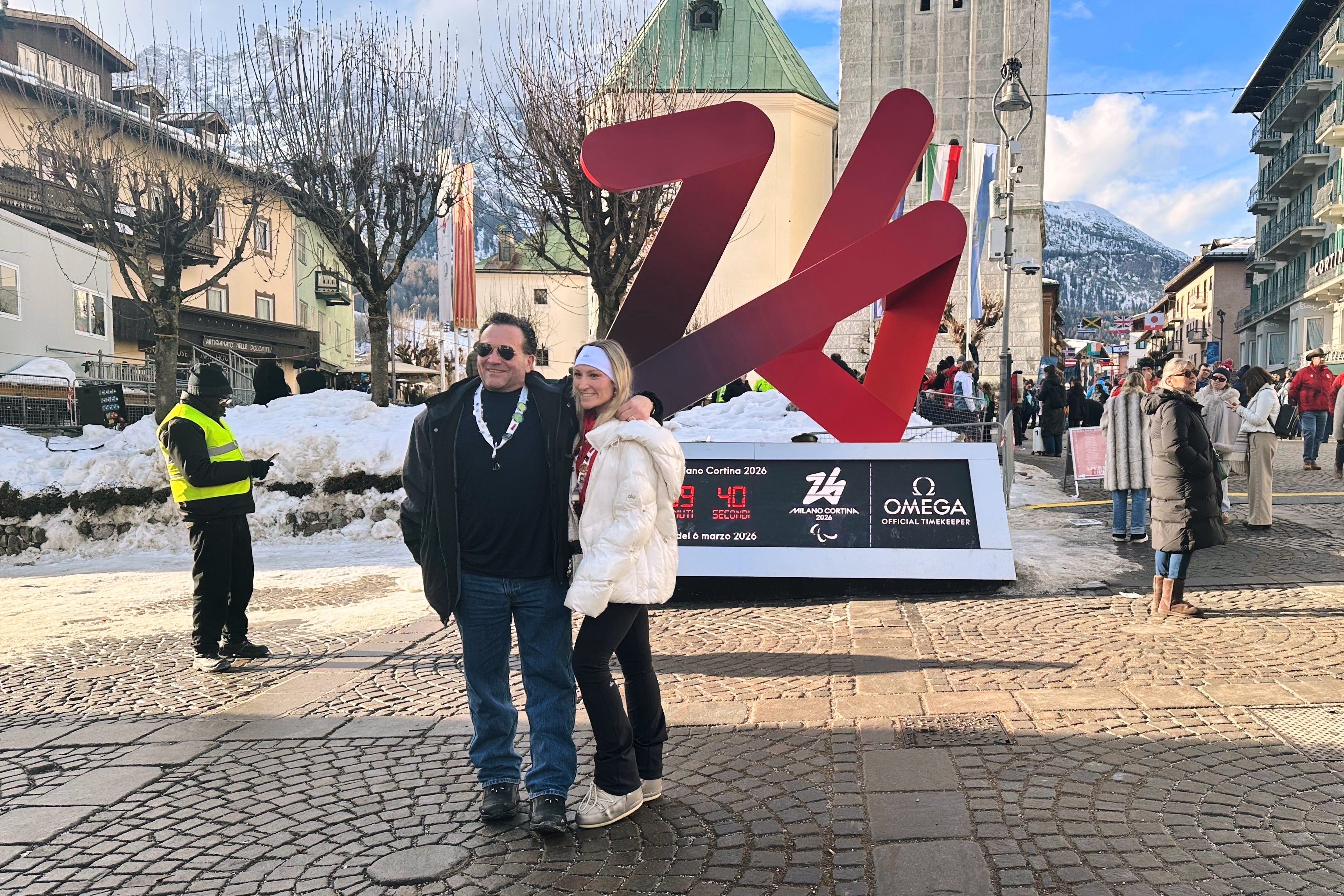 Karli Poliziani, center right, poses for a photo with her father, Len, as the temperature rose in the host city, during the 2026 Winter Olympics, in Cortina d'Ampezzo, Italy