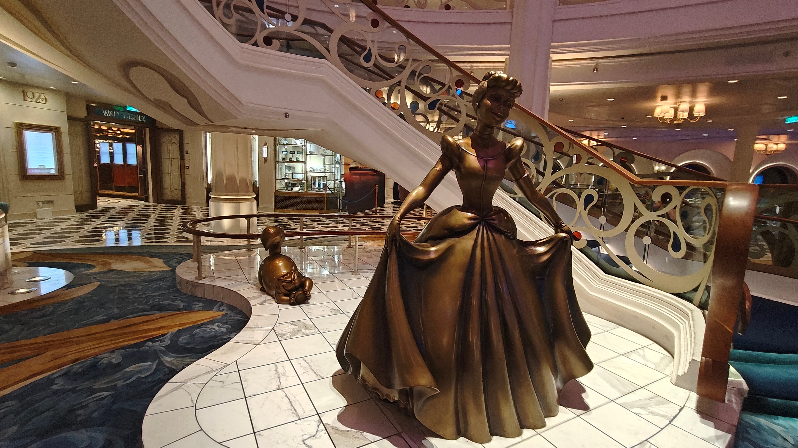 A bronze Cinderella statue welcomes guests into the Grand Hall aboard Disney Wish