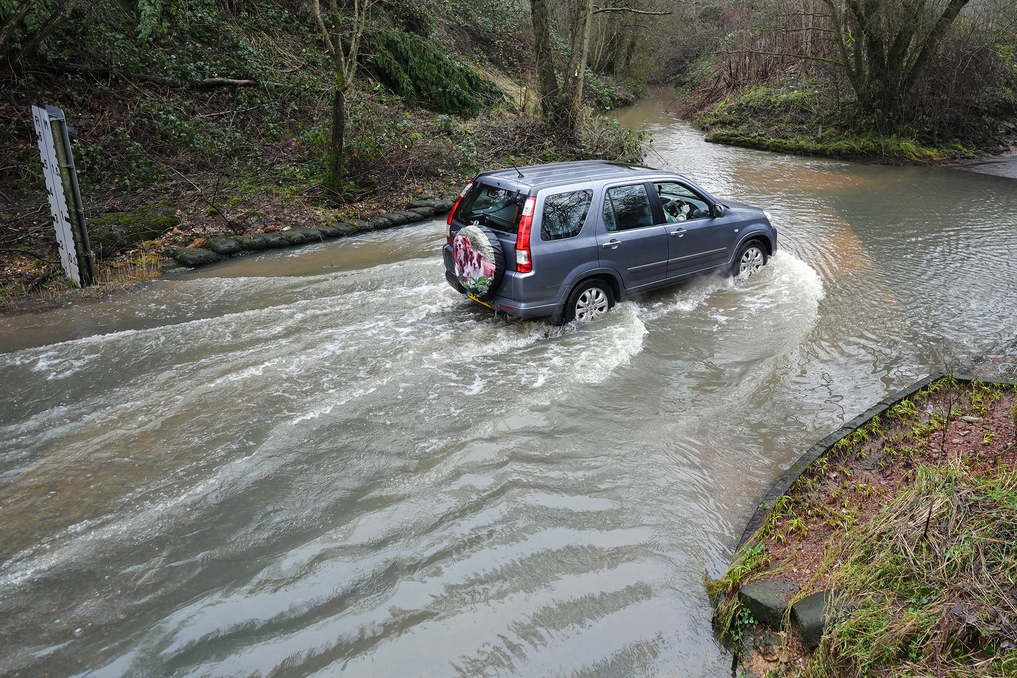 A car drives in floodwater in Houndsfield Lane, Birmingham