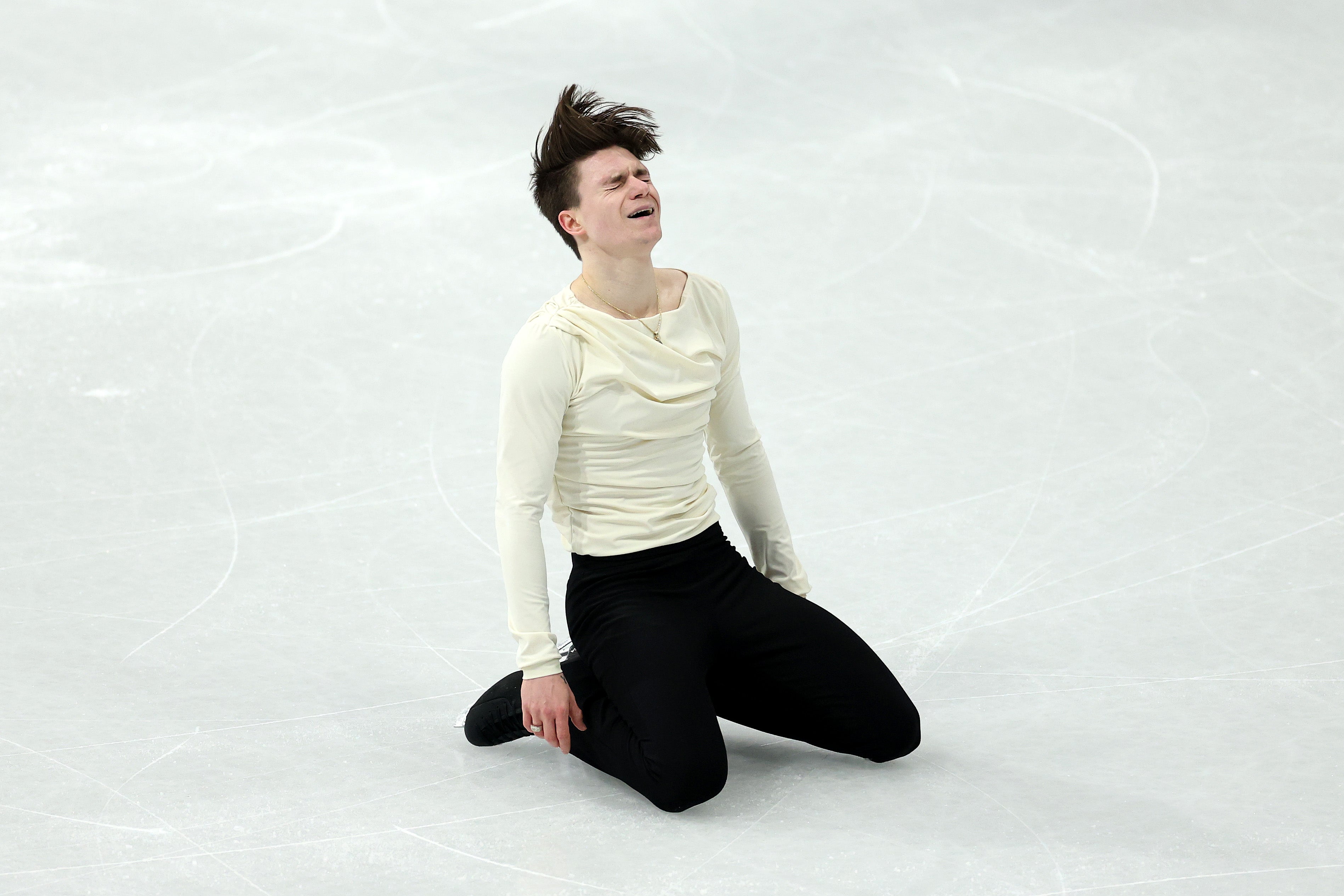 <p>As the 24-year-old awaited his score, he held up a childhood photograph of himself holding hands with his parents, prompting cheers from spectators at the Milano Ice Skating Arena</p>