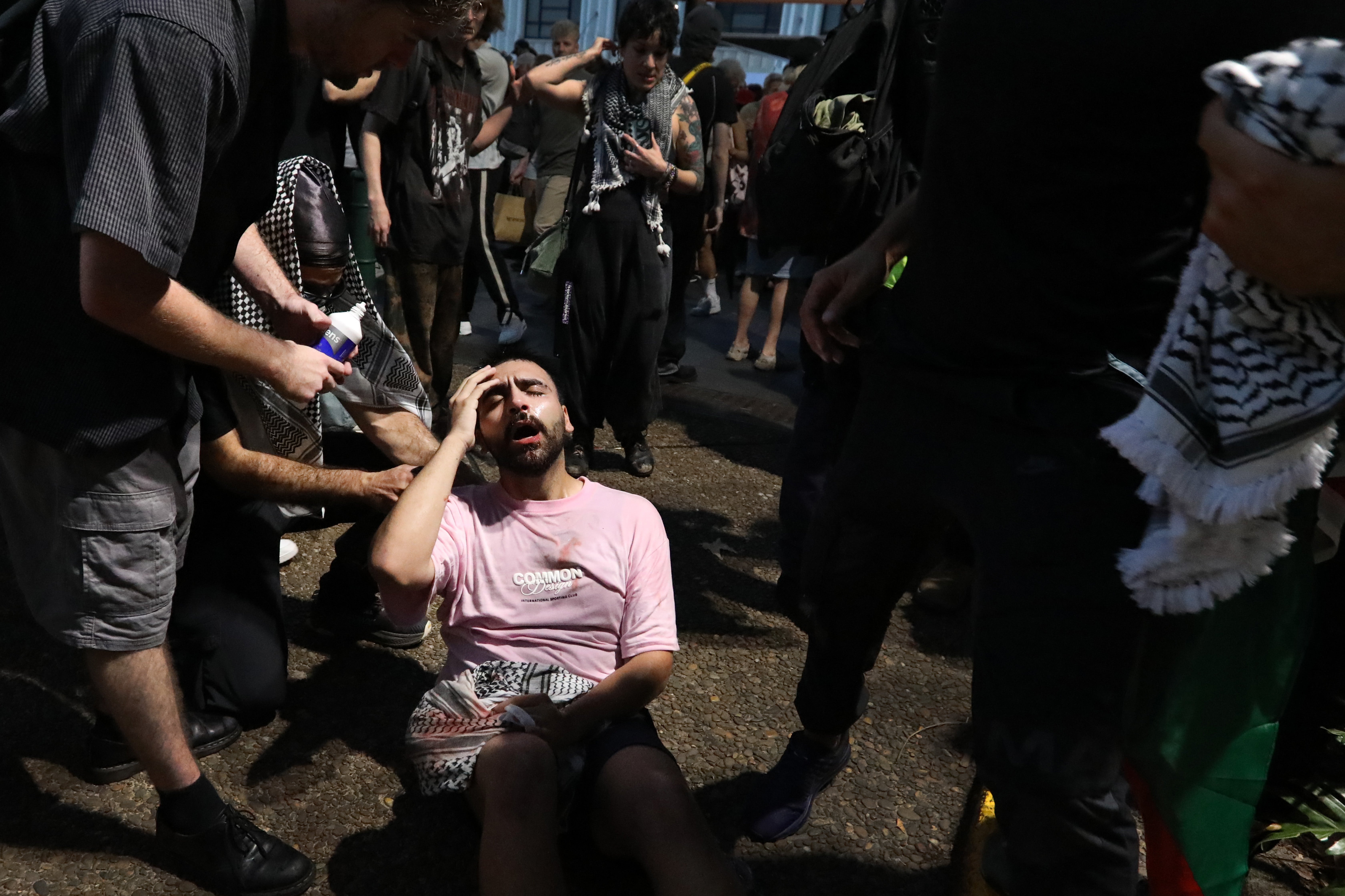 A protester receives assistance after being pepper sprayed by NSW Police during a protest against the visit of Israel's President Isaac Herzog on 9 February 2026 in Sydney, Australia