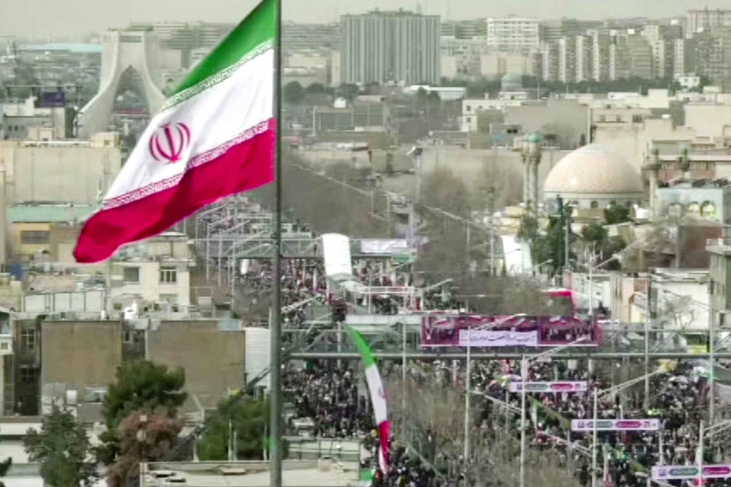 This grab taken from handout video footage released by Iran Press on February 11, 2026, shows people marching near Azadi Tower in Tehran to mark the 47th anniversary of the 1979 Islamic revolution.